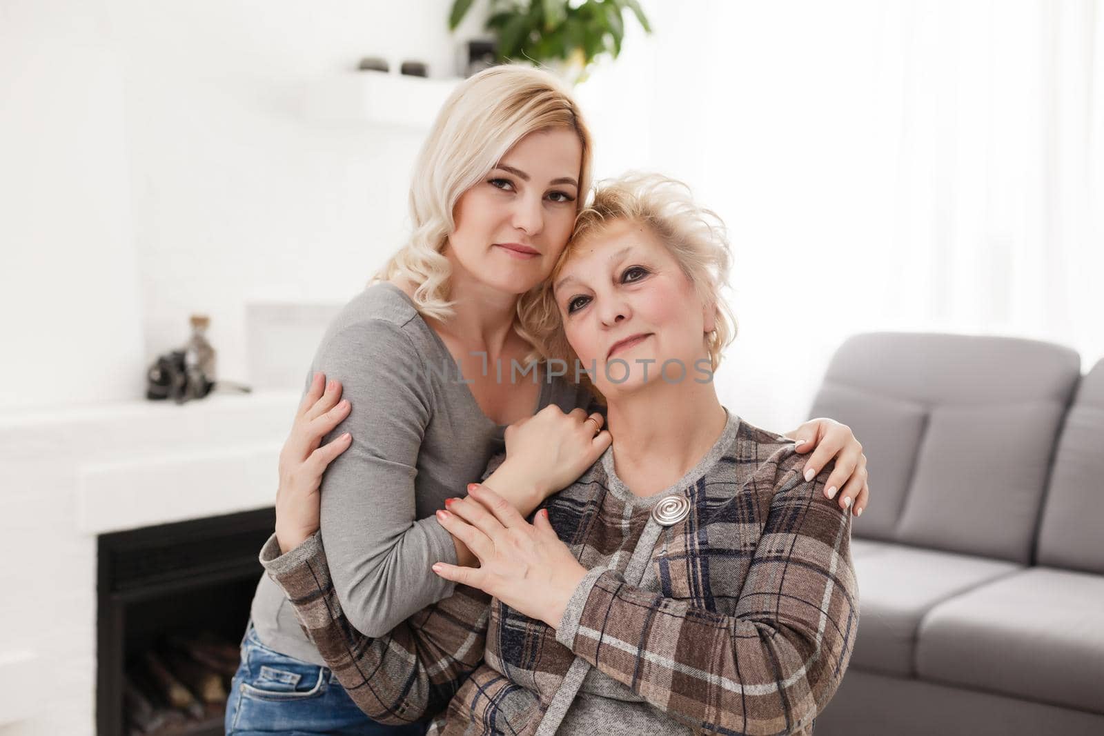 happy senior mother and adult daughter closeup portrait at home by Andelov13