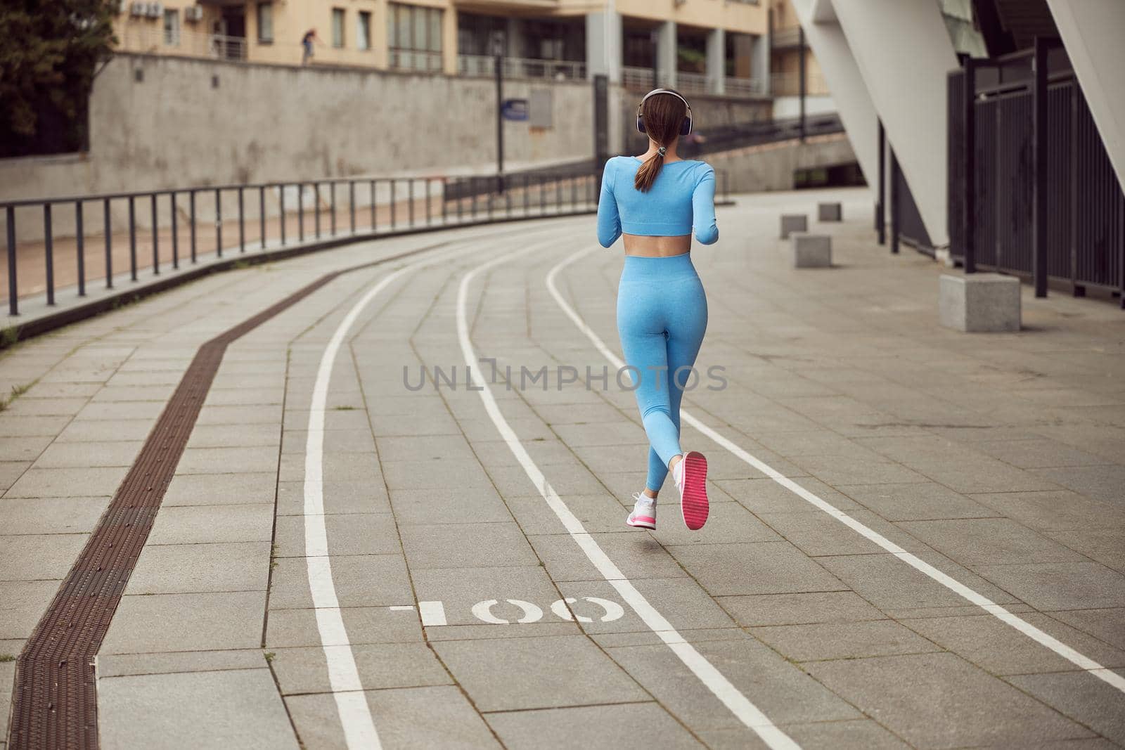 Beautiful fit caucasian woman is doing exercises outdoors at the city by Yaroslav_astakhov