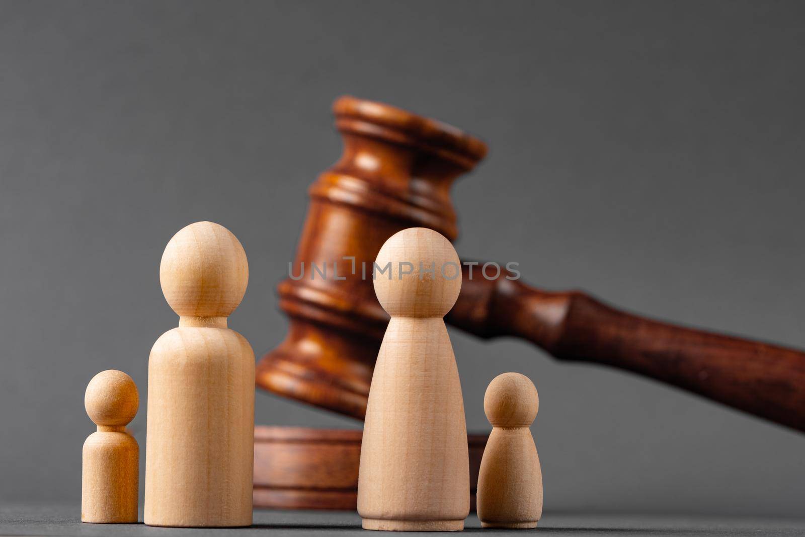 Wooden toy family and judge mallet close up. Family divorce concept