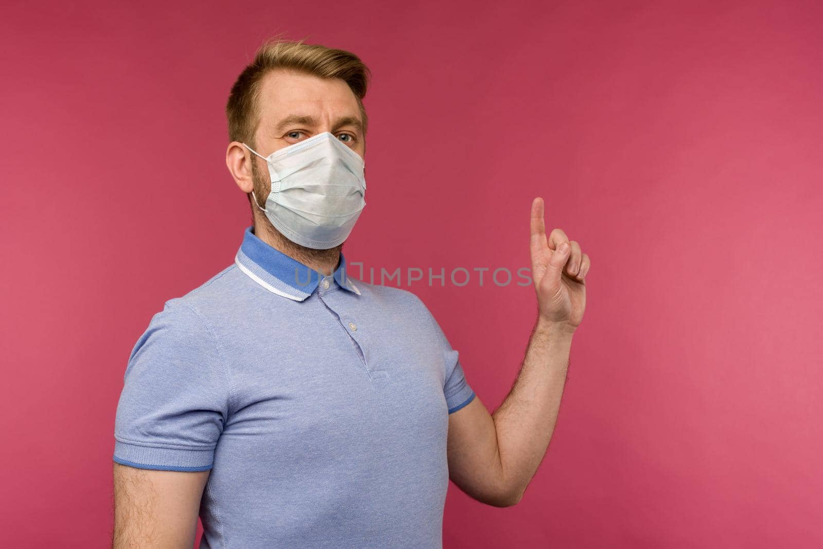 Protection against contagious disease, coronavirus. Man wearing hygienic mask to prevent infection, airborne respiratory illness such as flu, 2019-nCoV. indoor studio shot isolated on red background