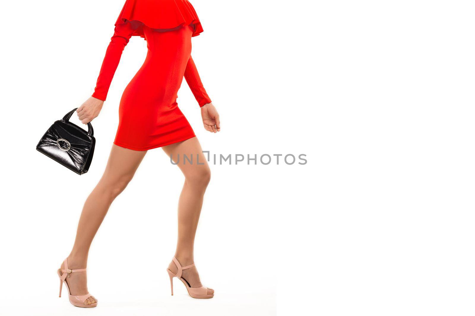 woman in red dress in high heels with hand bag isolated on white