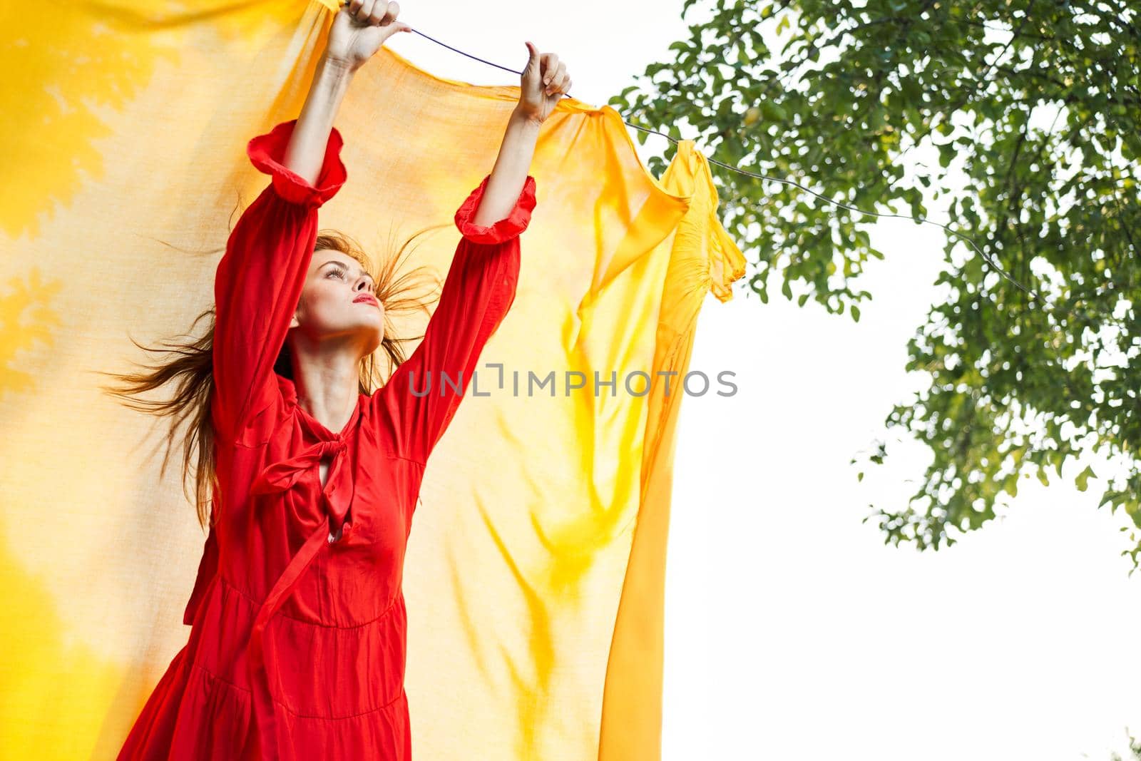 woman in red dress outdoors yellow bedspread. High quality photo