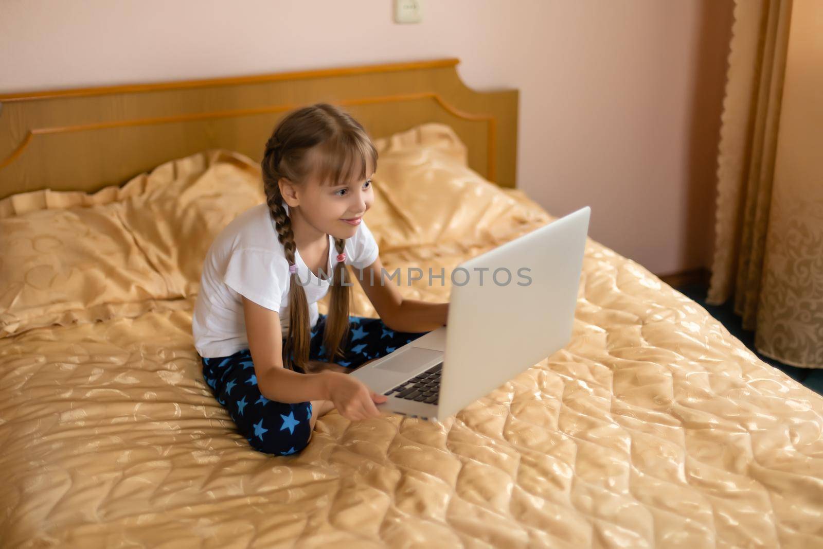 education, free time, technology and internet concept - little student girl with laptop pc at home