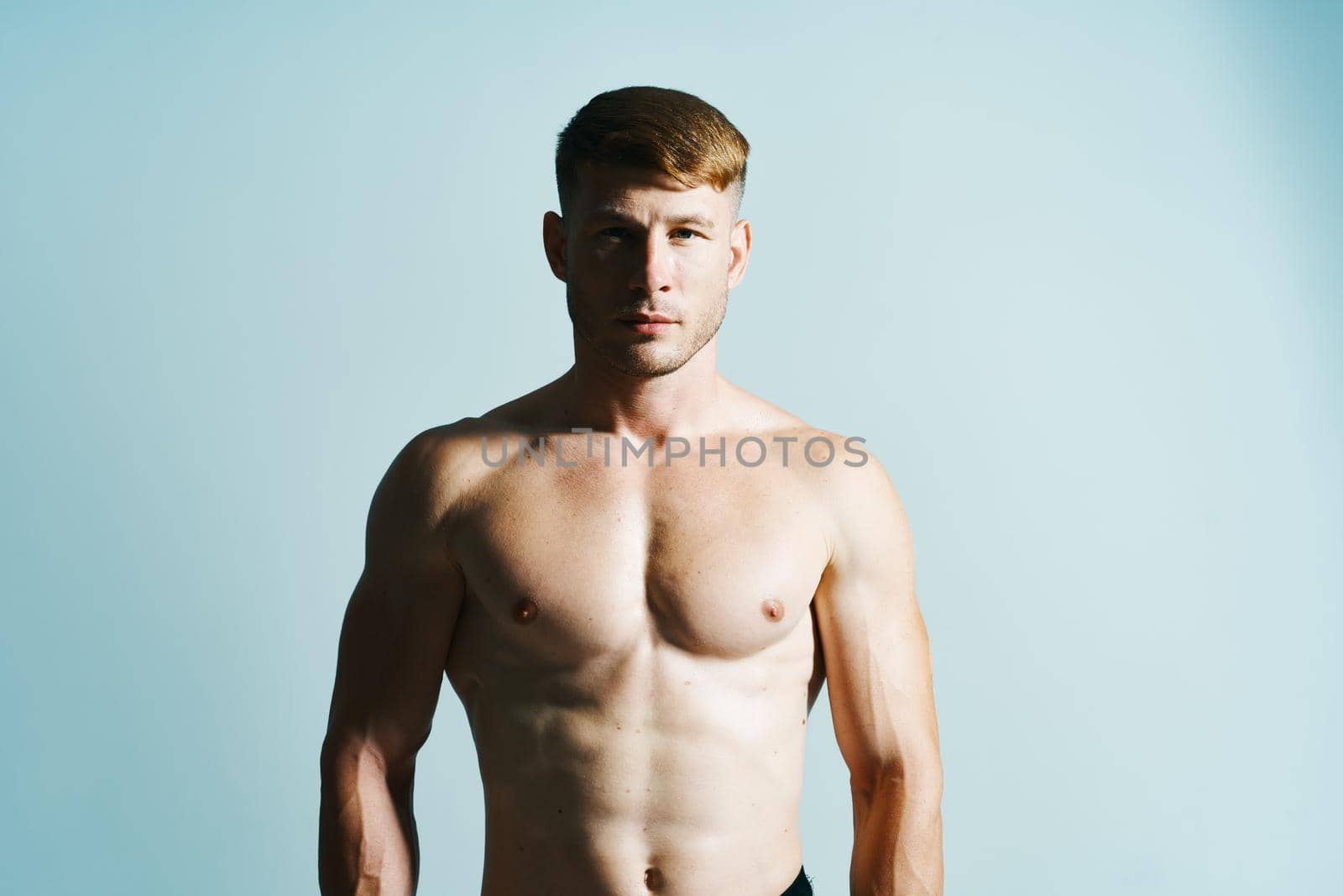 bodybuilder with muscular body posing press blue background by Vichizh
