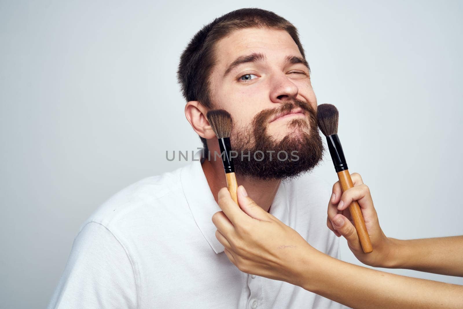 bearded man in white shirt cosmetics makeup. High quality photo