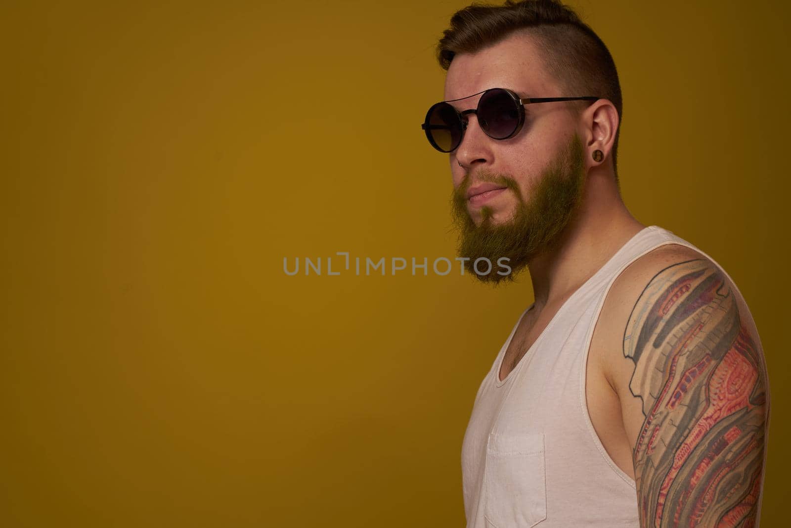 man in a white t-shirt tattoos on his arms fashion glasses modern style. High quality photo