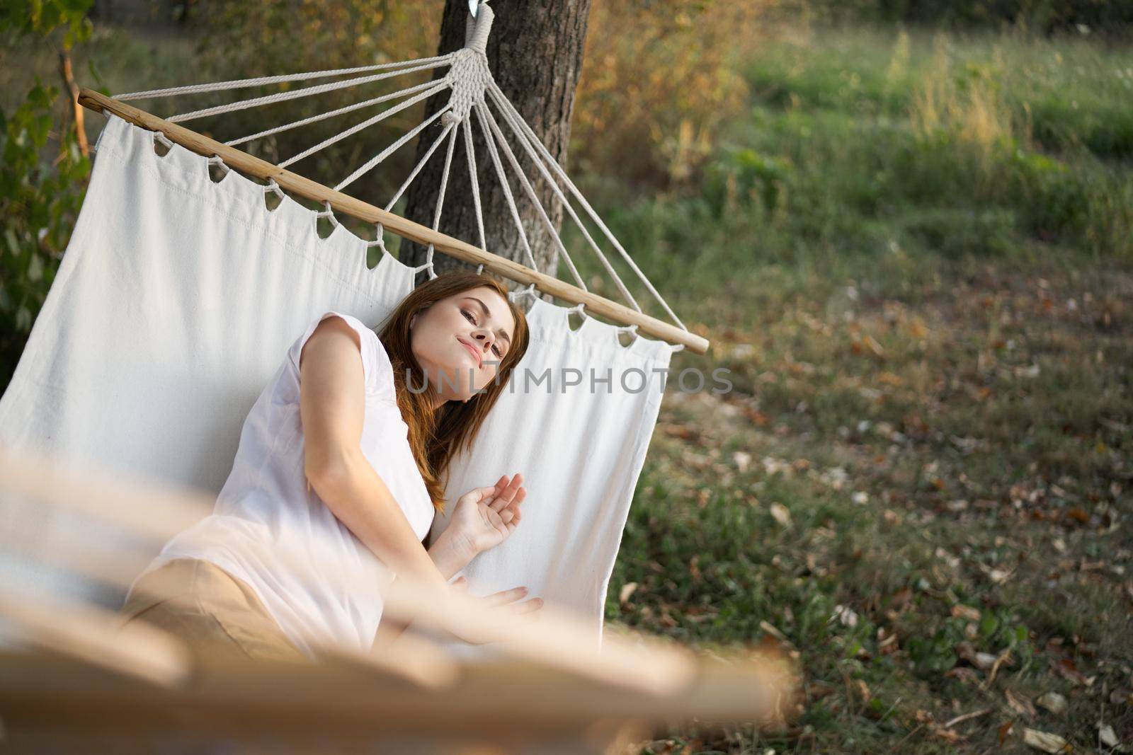 woman relaxing in nature in a hammock garden fresh air by Vichizh