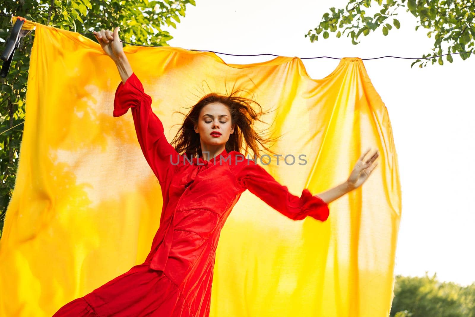 attractive woman in red dress posing yellow background nature. High quality photo