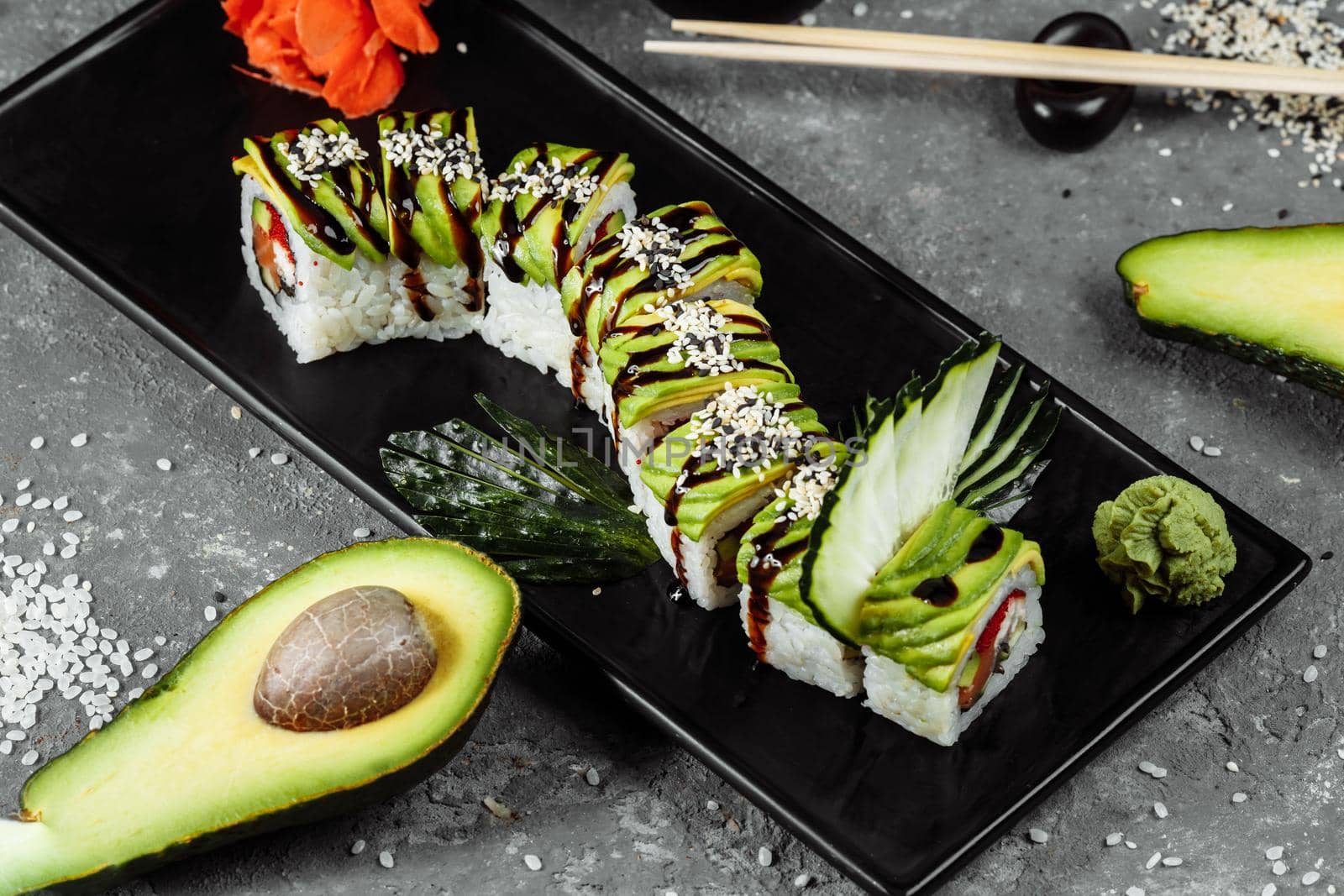 Green dragon sushi roll with eel, avocado, cucumber and ginger, accompanied with fried tempura shrimp. Traditional asian rice sushi healthy seafood by UcheaD