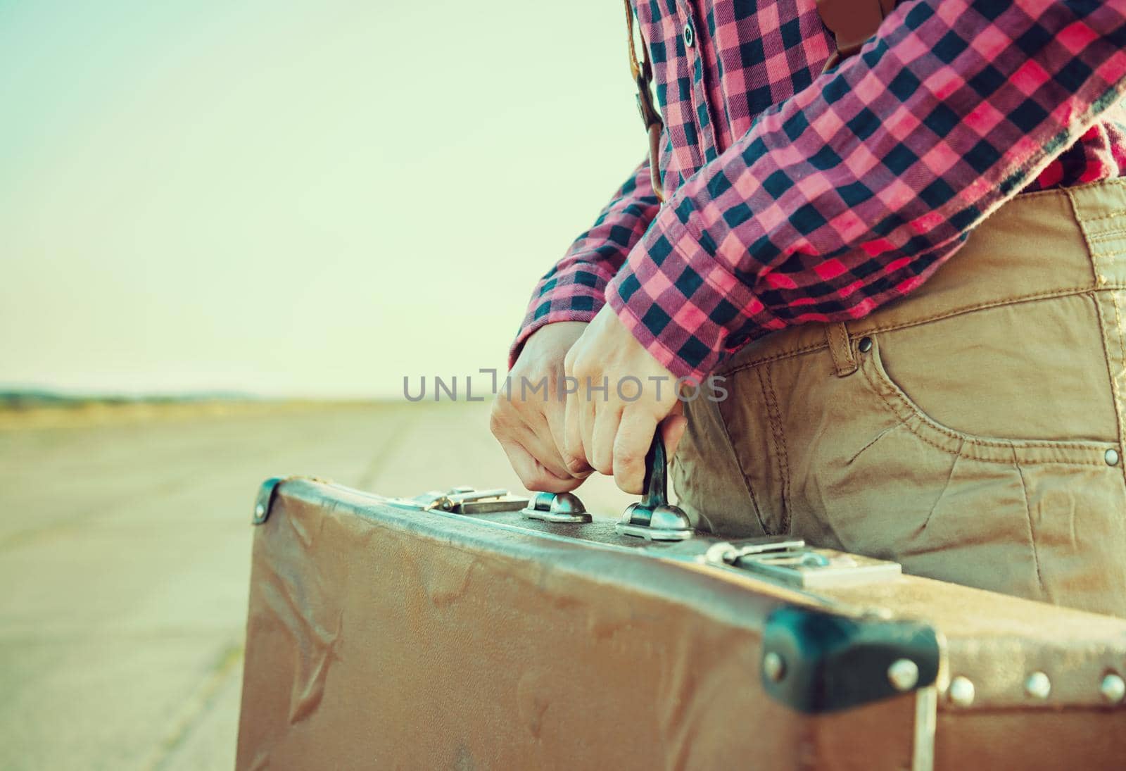 Unrecognizable woman holds vintage suitcase, close-up