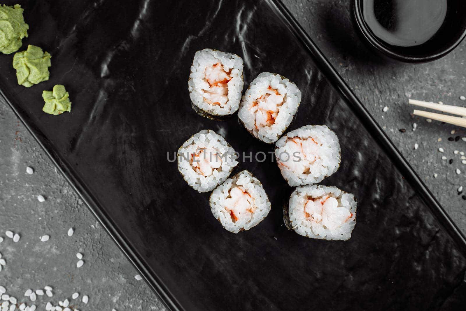 Simple maki with shrimp. Sushi on a gray background.