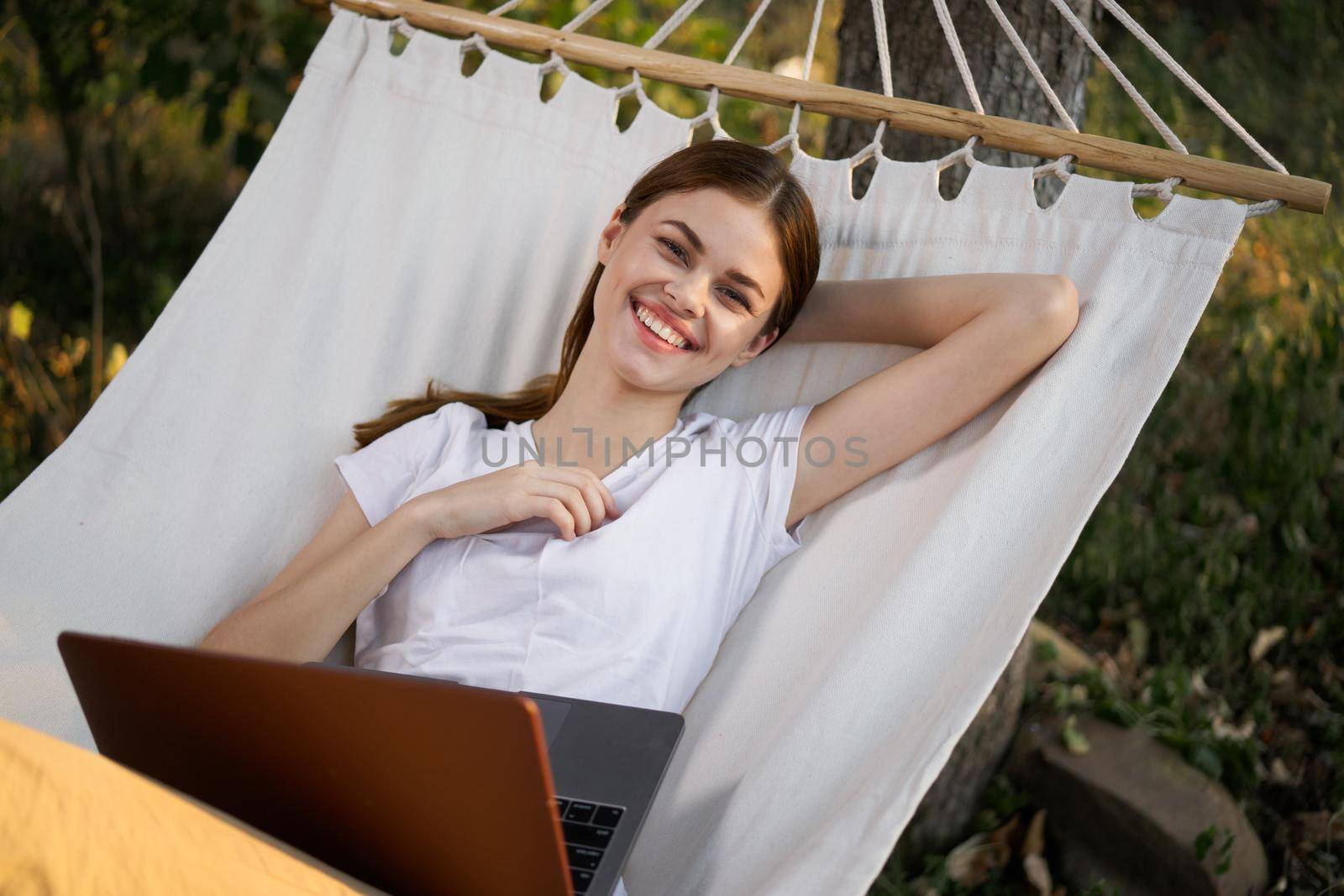 woman working on laptop in nature hammock freelance by Vichizh