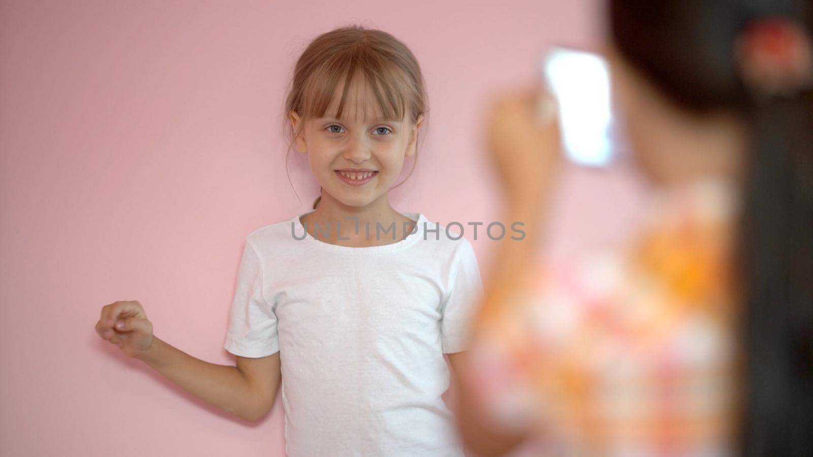 two little girls taking photo with a smartphone by Andelov13