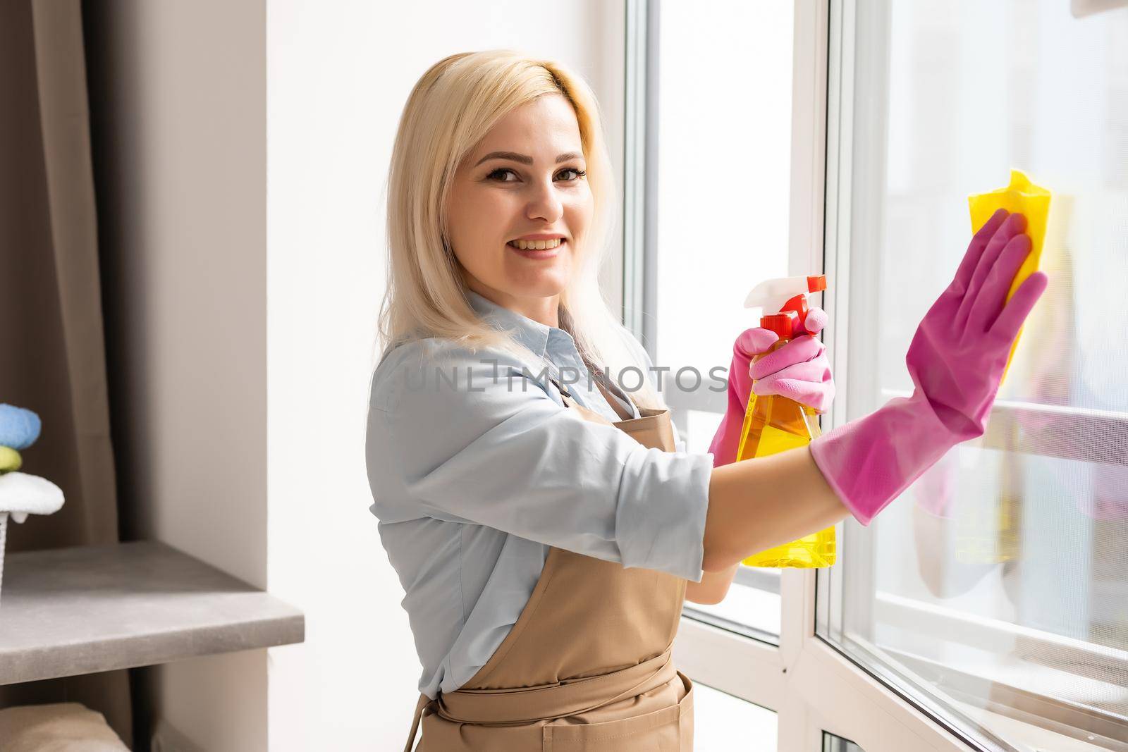 The woman washes a window in apartment