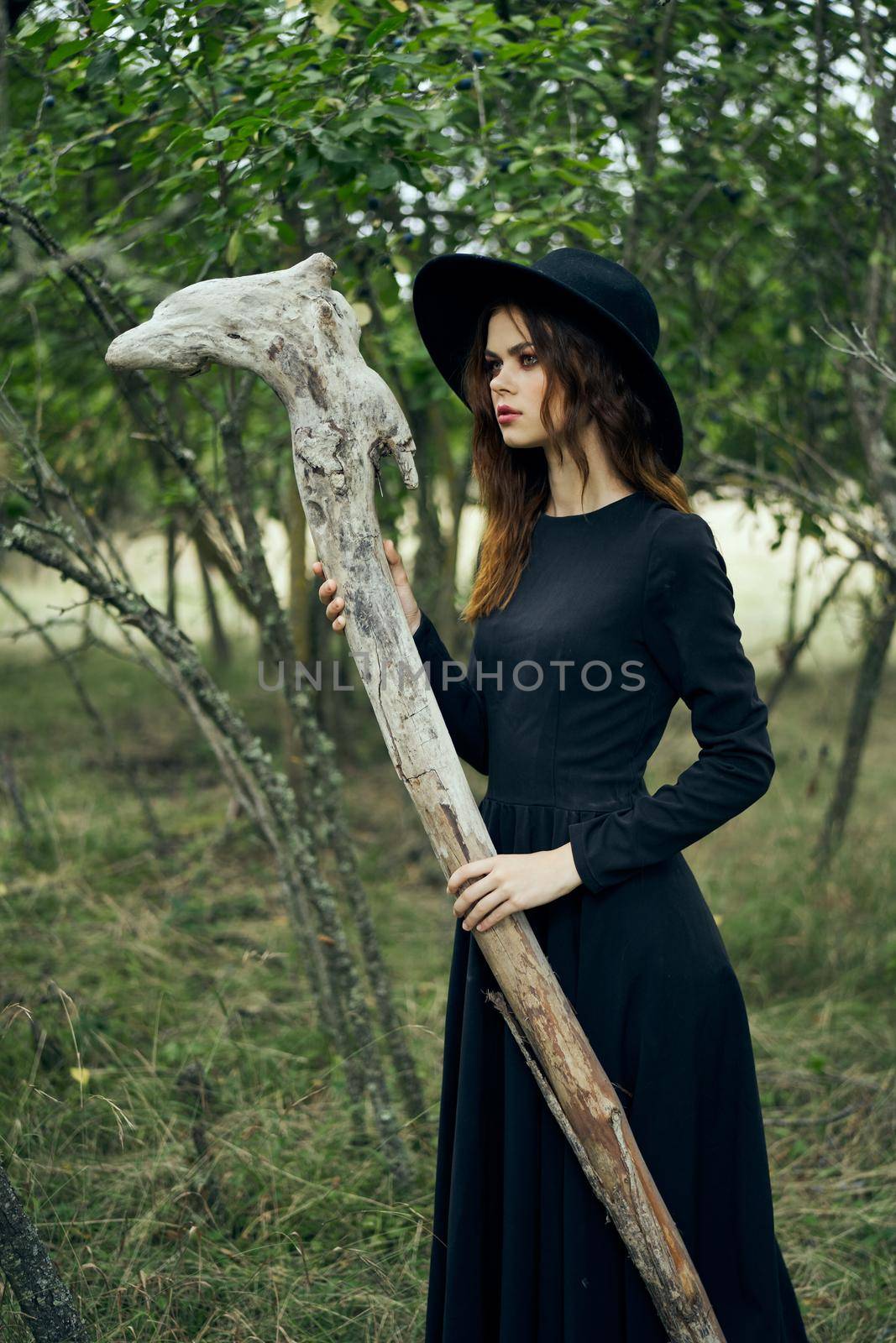 woman in black suit Witch in a fantasy forest. High quality photo