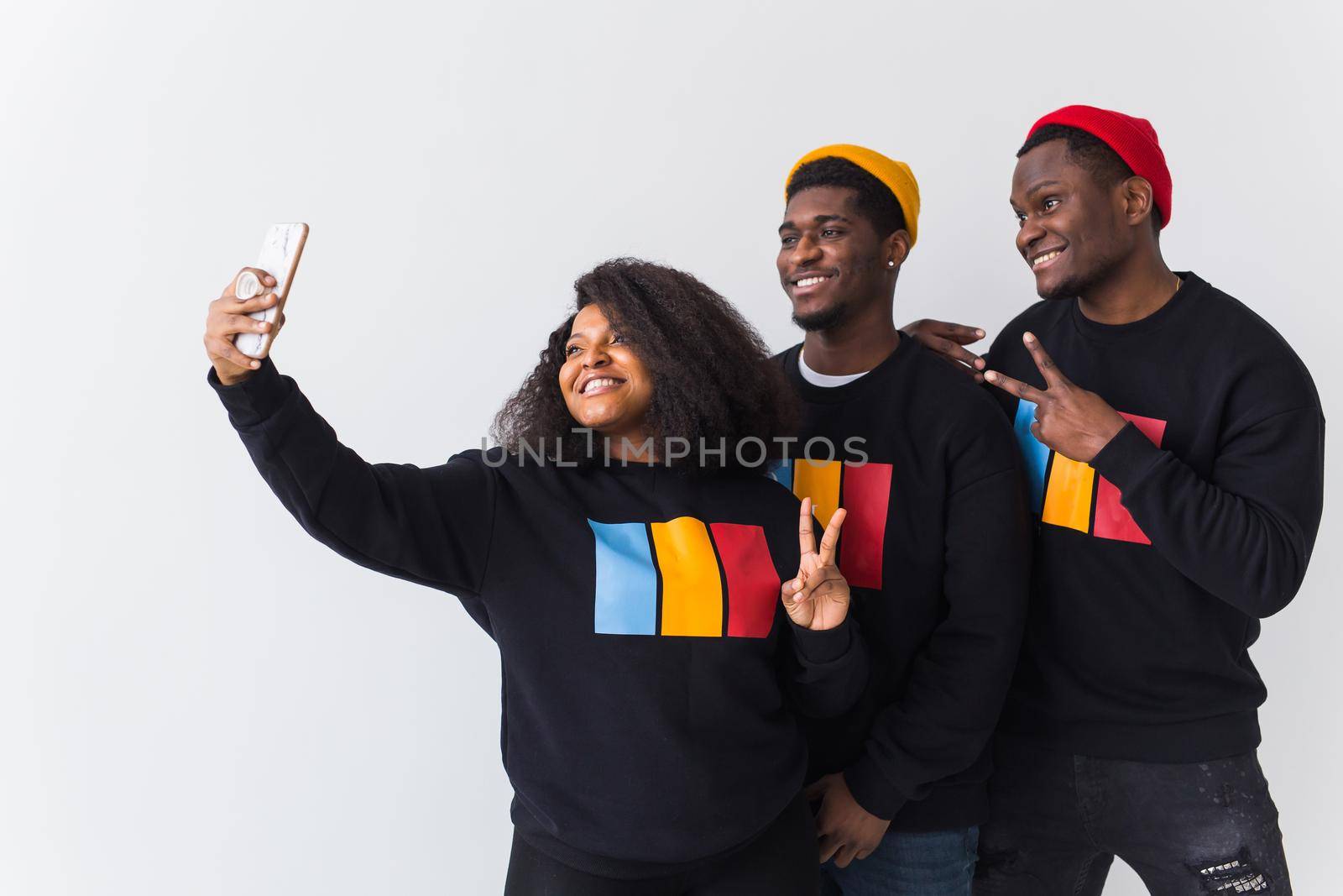Friendship and fun concept - Group of friends afro american men and woman taking selfie in studio on white background. by Satura86