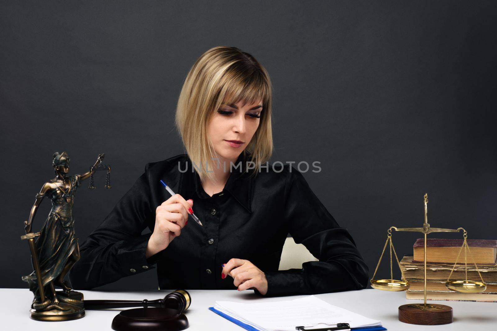 A young fair woman judge works in her office. - image