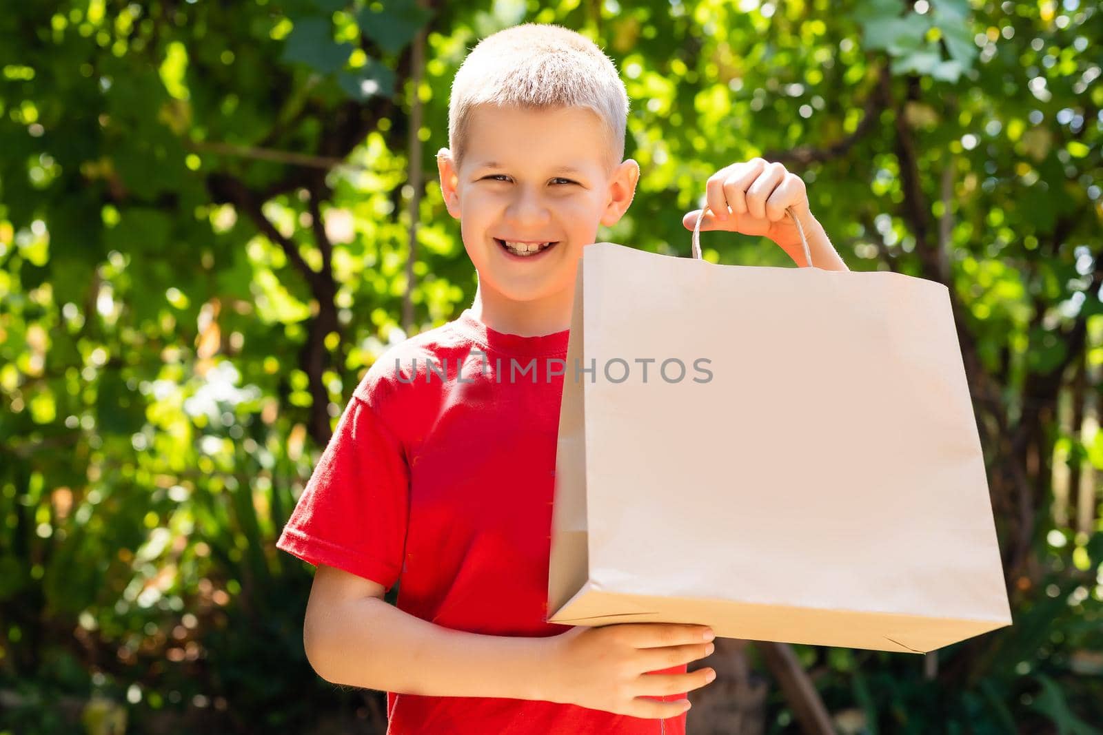 Happy boy with shopping bags. summer sales, black friday. cyber monday. Big sales for children. craft packages in hand. many purchases and gifts.
