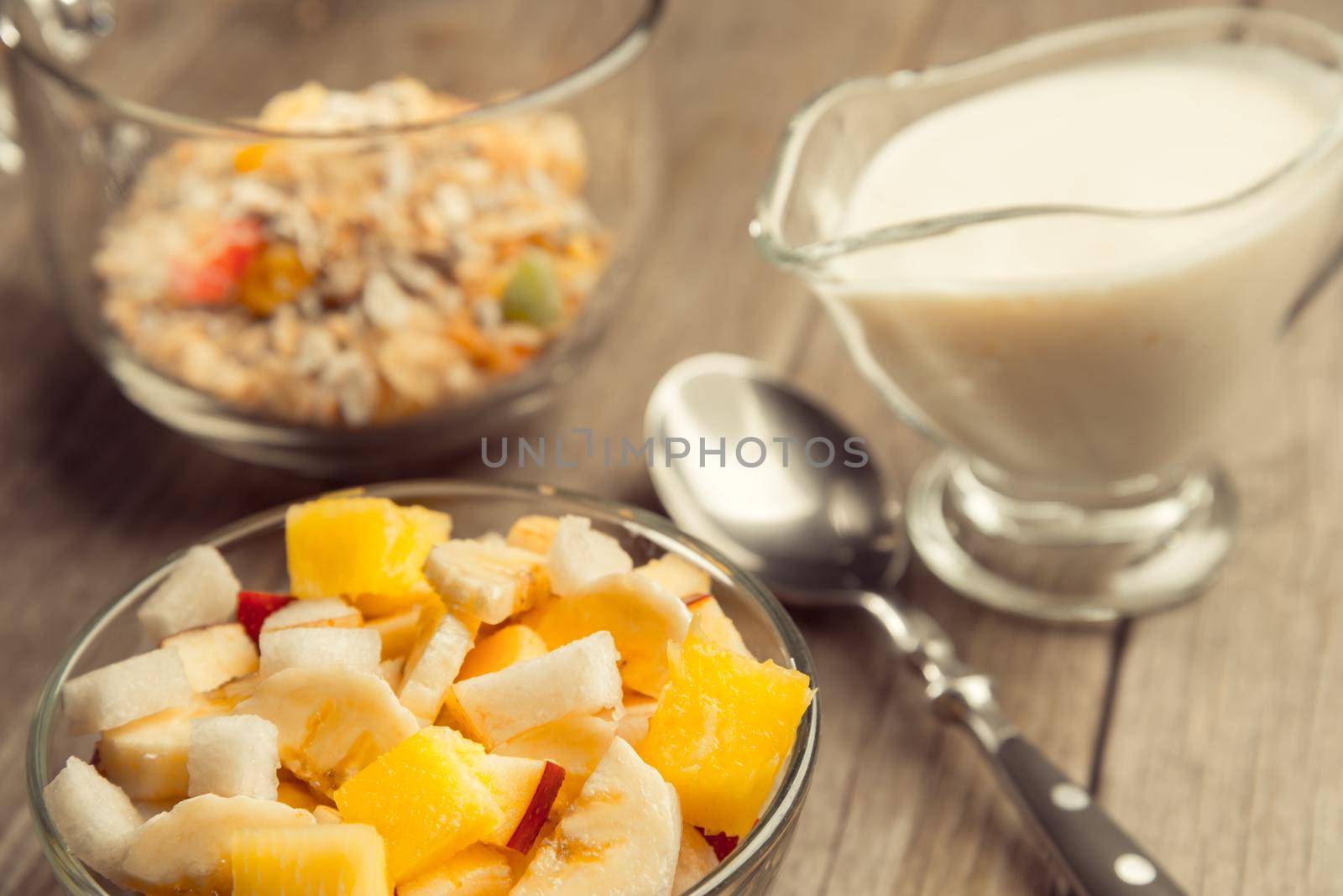 Fruit salad and muesli for breakfast on a wooden table