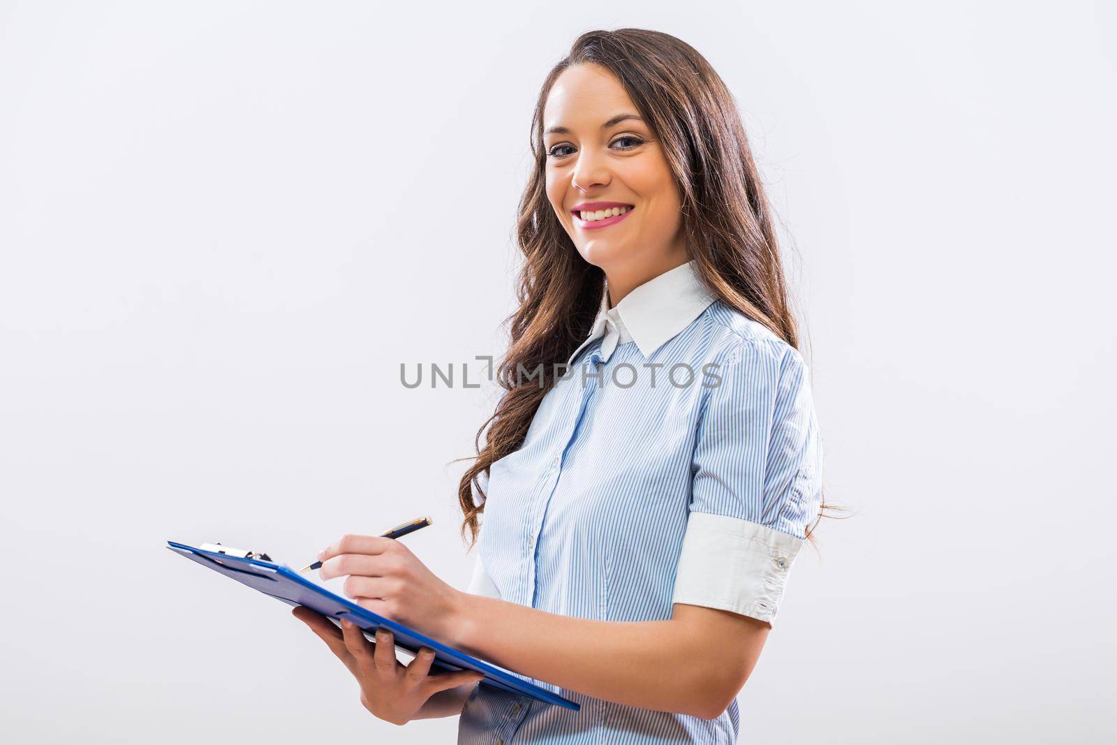 Portrait of beautiful businesswoman holding note pad by Bazdar