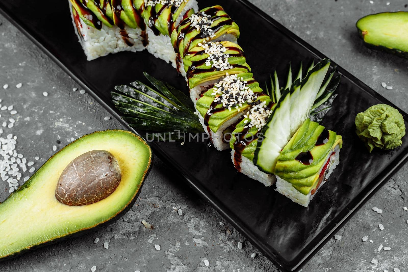 Green dragon sushi roll with eel, avocado, cucumber and ginger, accompanied with fried tempura shrimp. Traditional asian rice sushi healthy seafood by UcheaD