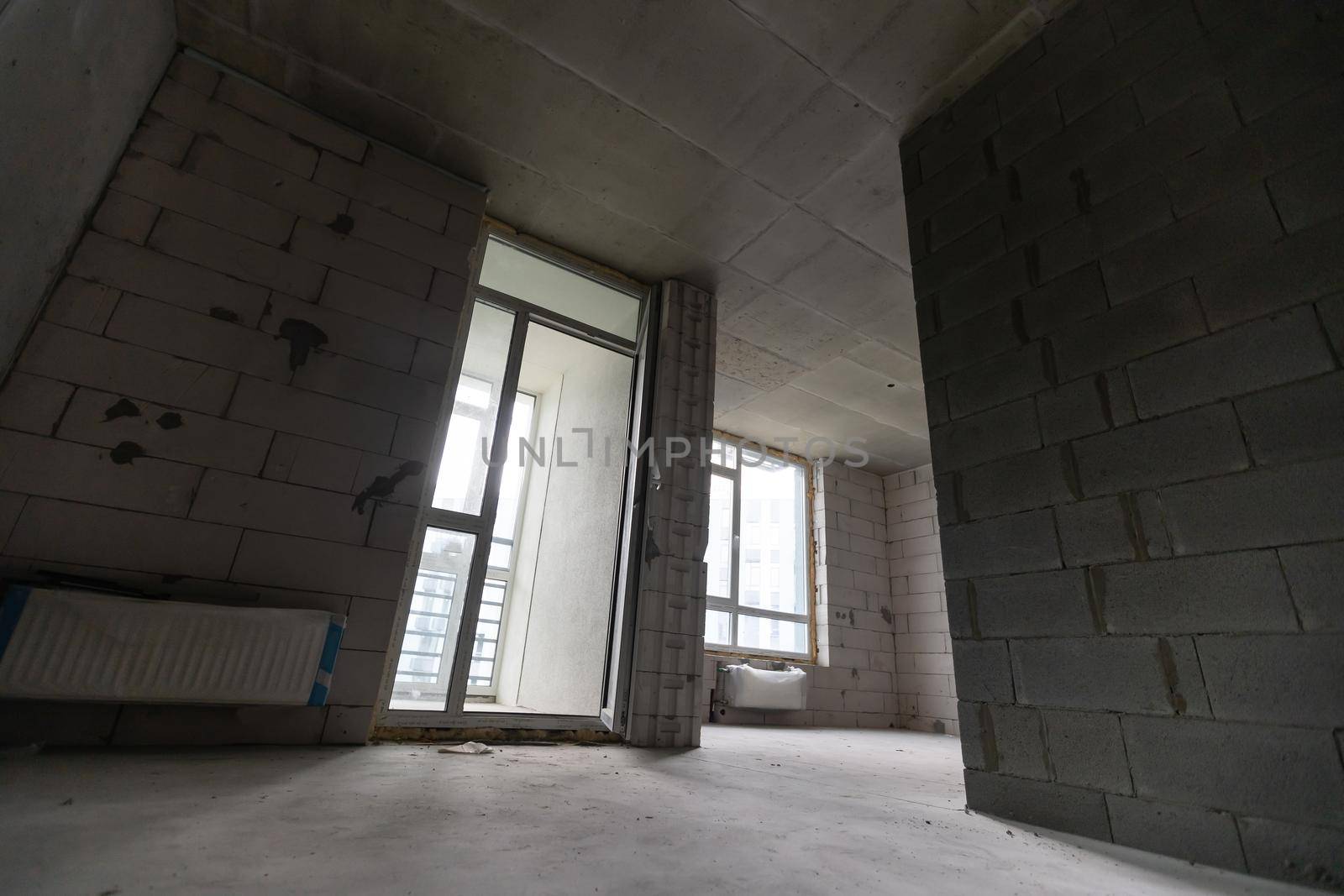 Small apartment without repair in a new building. A room in an unfinished house. Walls of foam block and concrete floor in a tiny apartment.