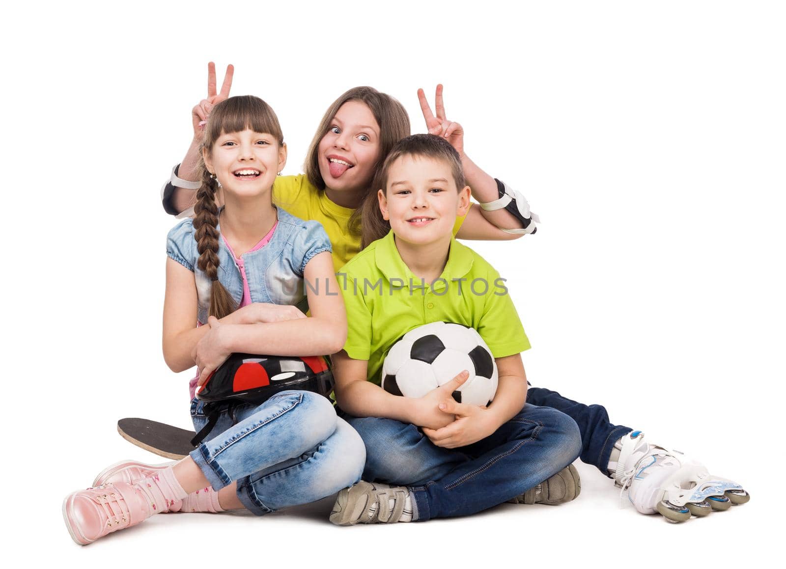 playful little boy and girls sitting on the floor with ball, skate and rollers isolated on white background