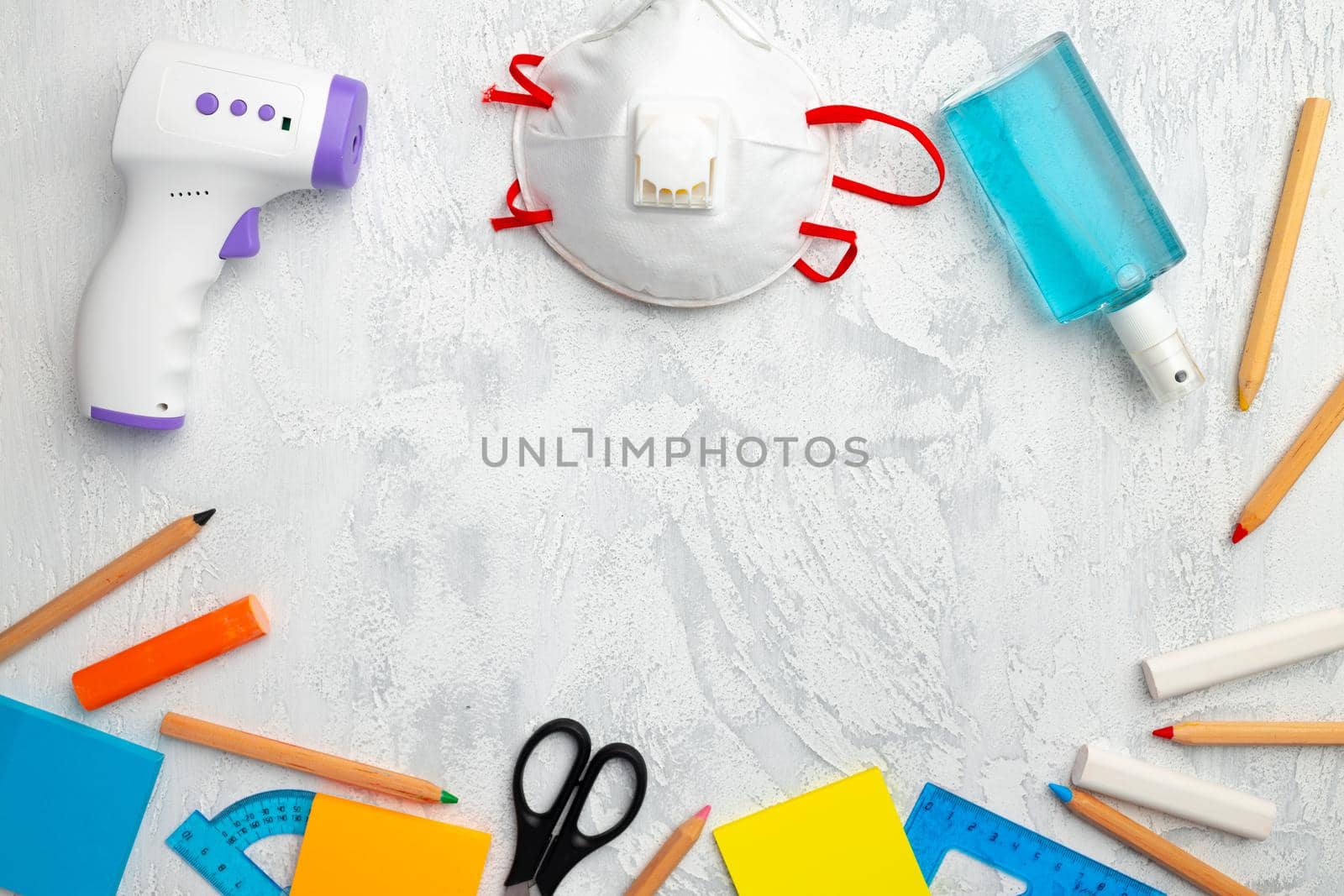 Medical face mask, hand sanitizer and stationery on white textured background top view