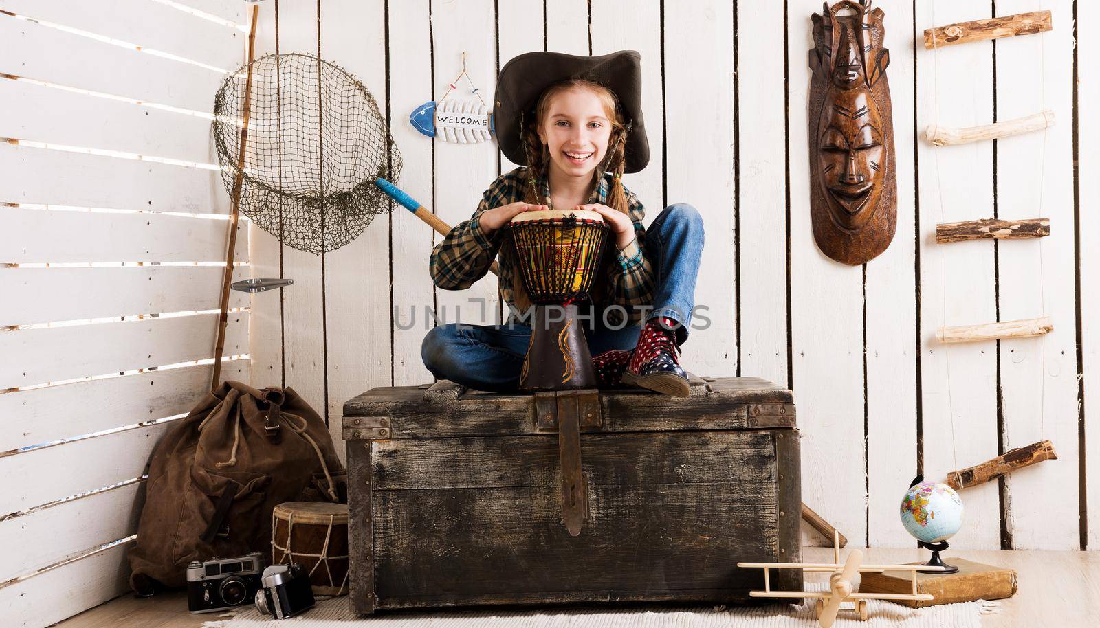 beautiful little girl in cowboy hat with drum sitting on big chest