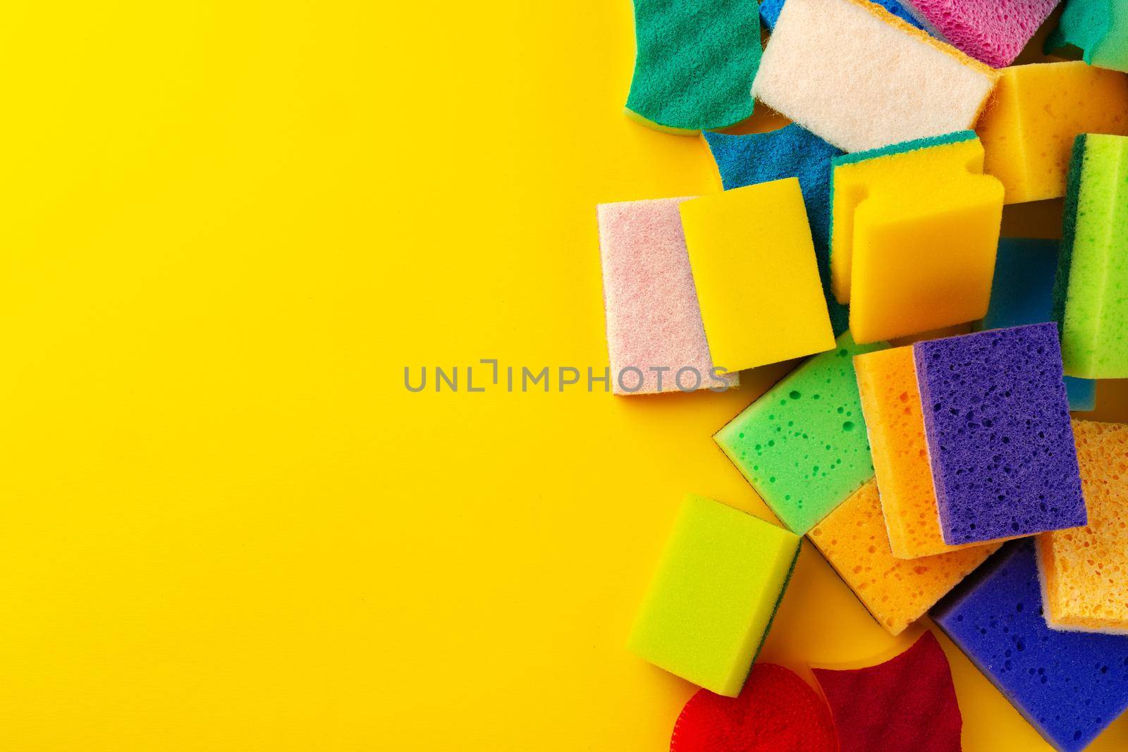 Pile of new cleaning sponges on yellow background, top view photo