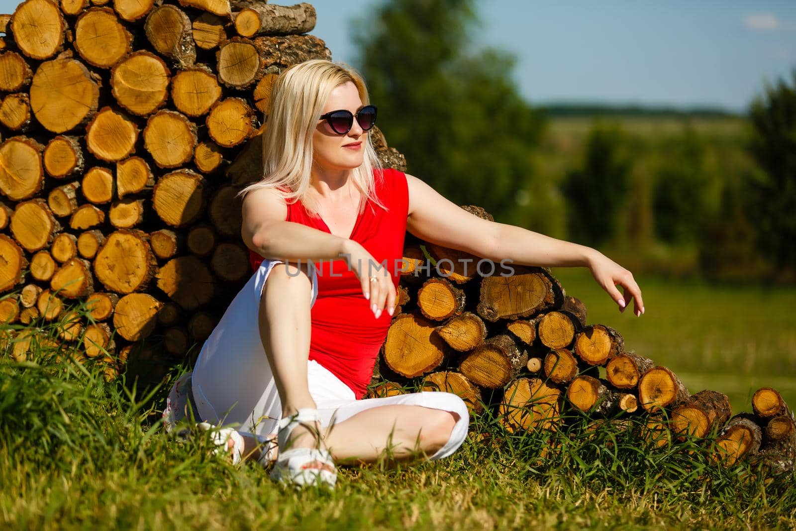 woman sitting against tree in the park on the grass