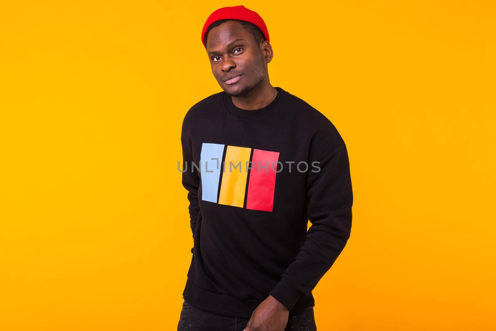 Portrait handsome young black man dressed in jeans and hoodie on white background. Street fashion and modern youth culture