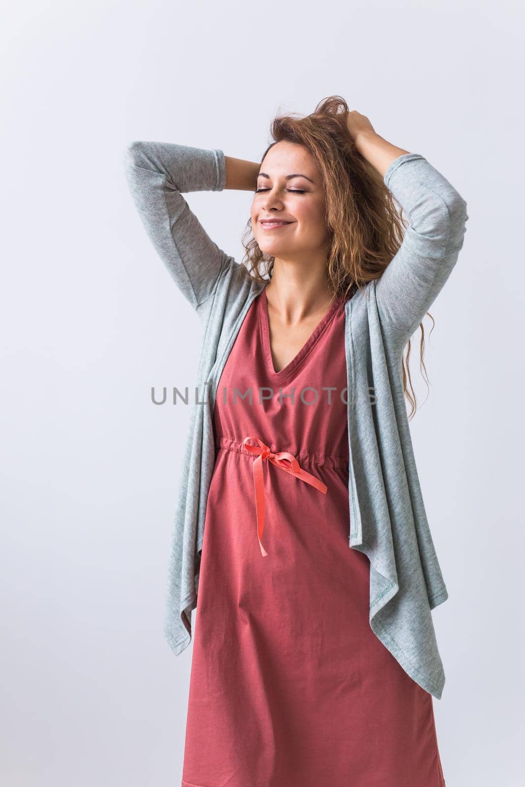 Beautiful young woman smiling against white background. Comfortable homewear, home relaxation and female fashion.