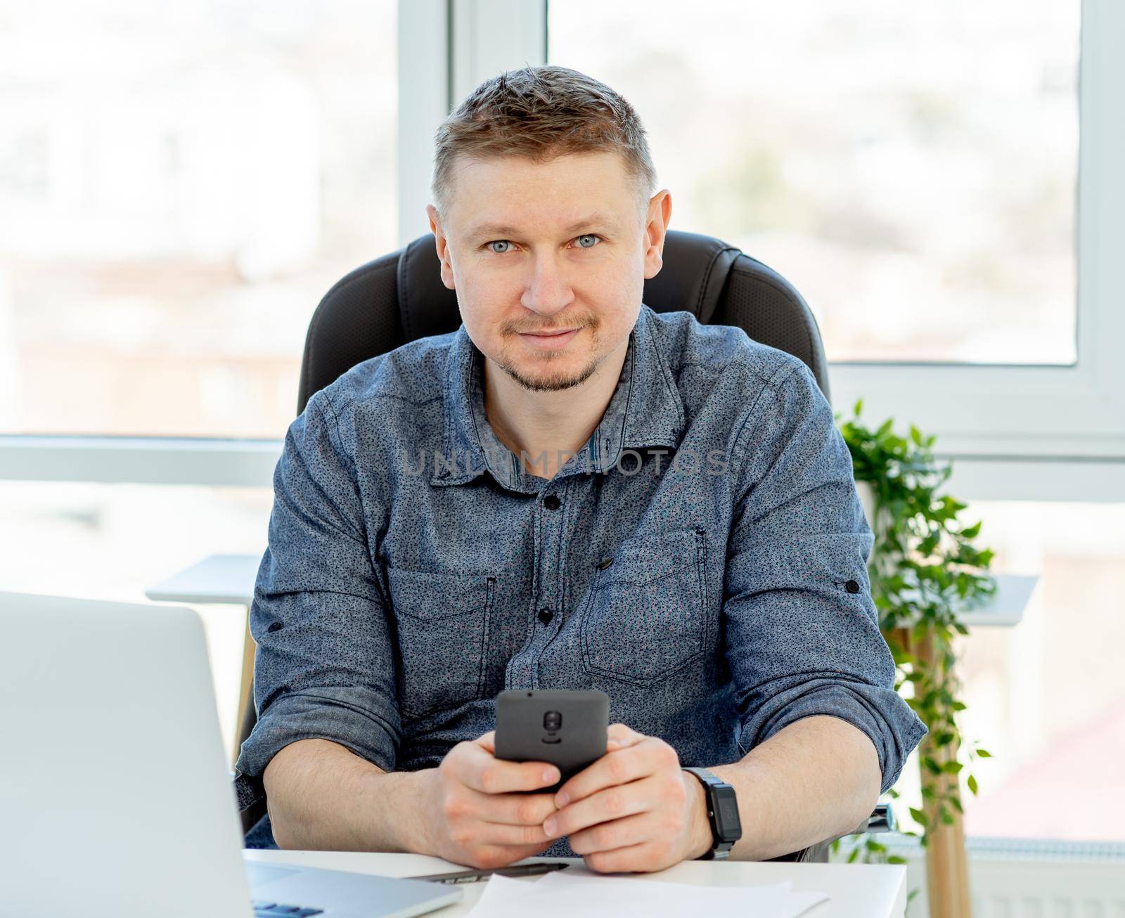 Smiling man working in light office