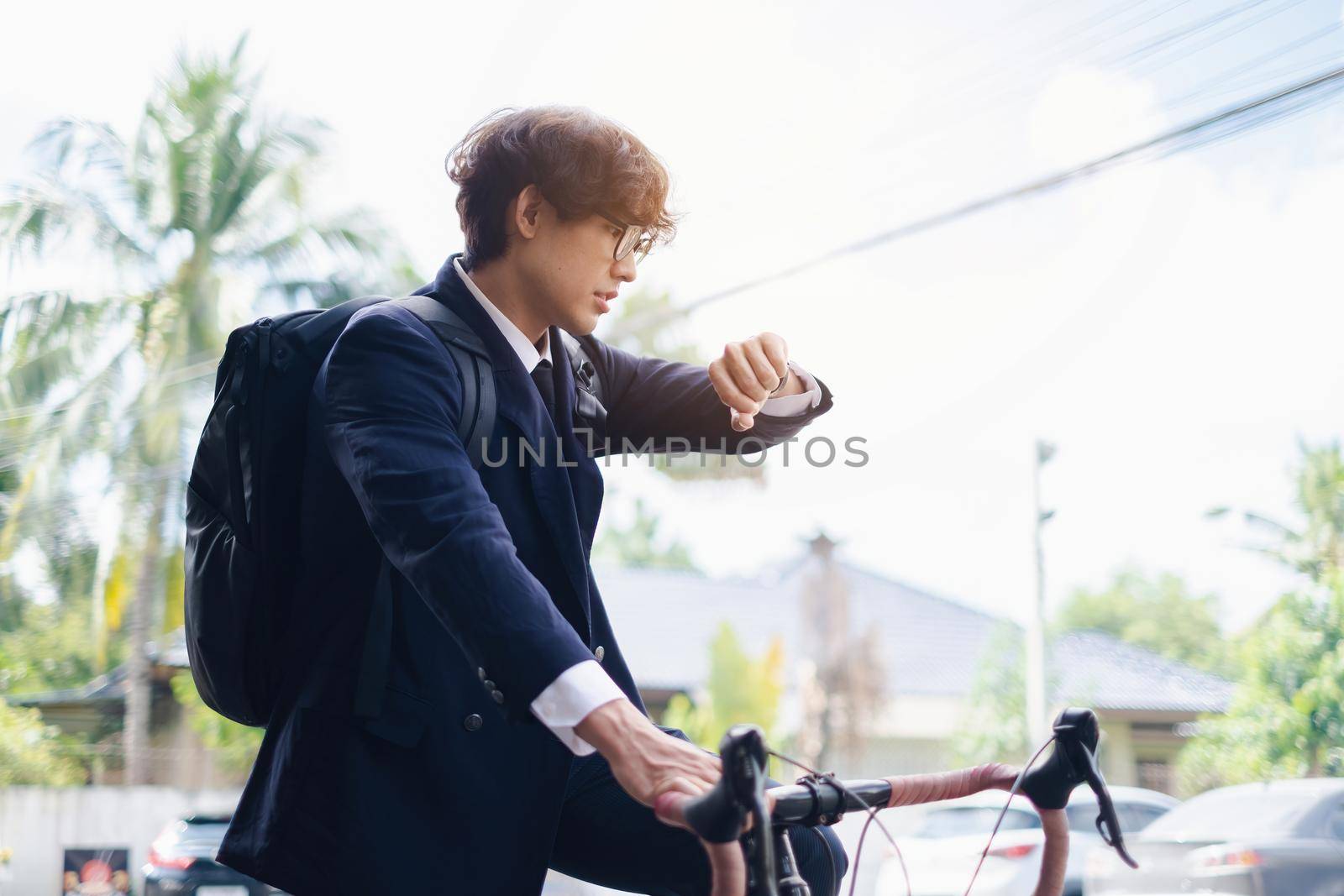 Handsome young asian businessman in suit have smiling with bicycle go to work at morning.