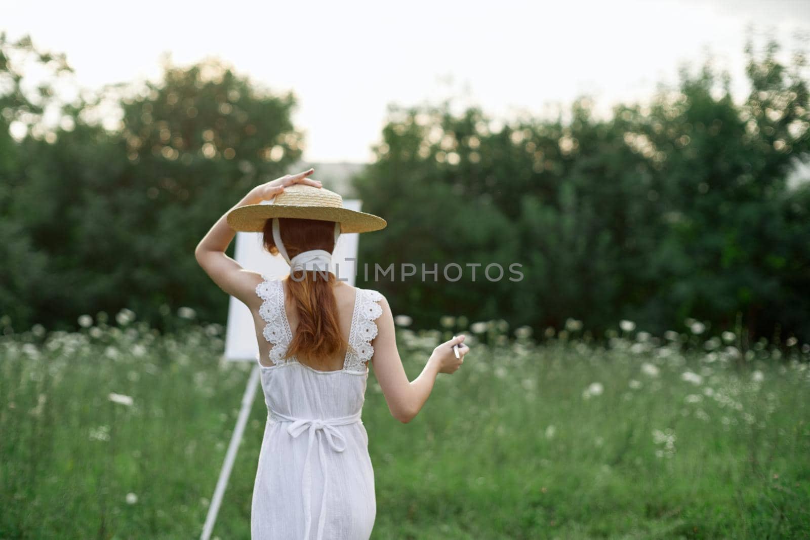 pretty woman in white dress outdoors drawing art creative. High quality photo