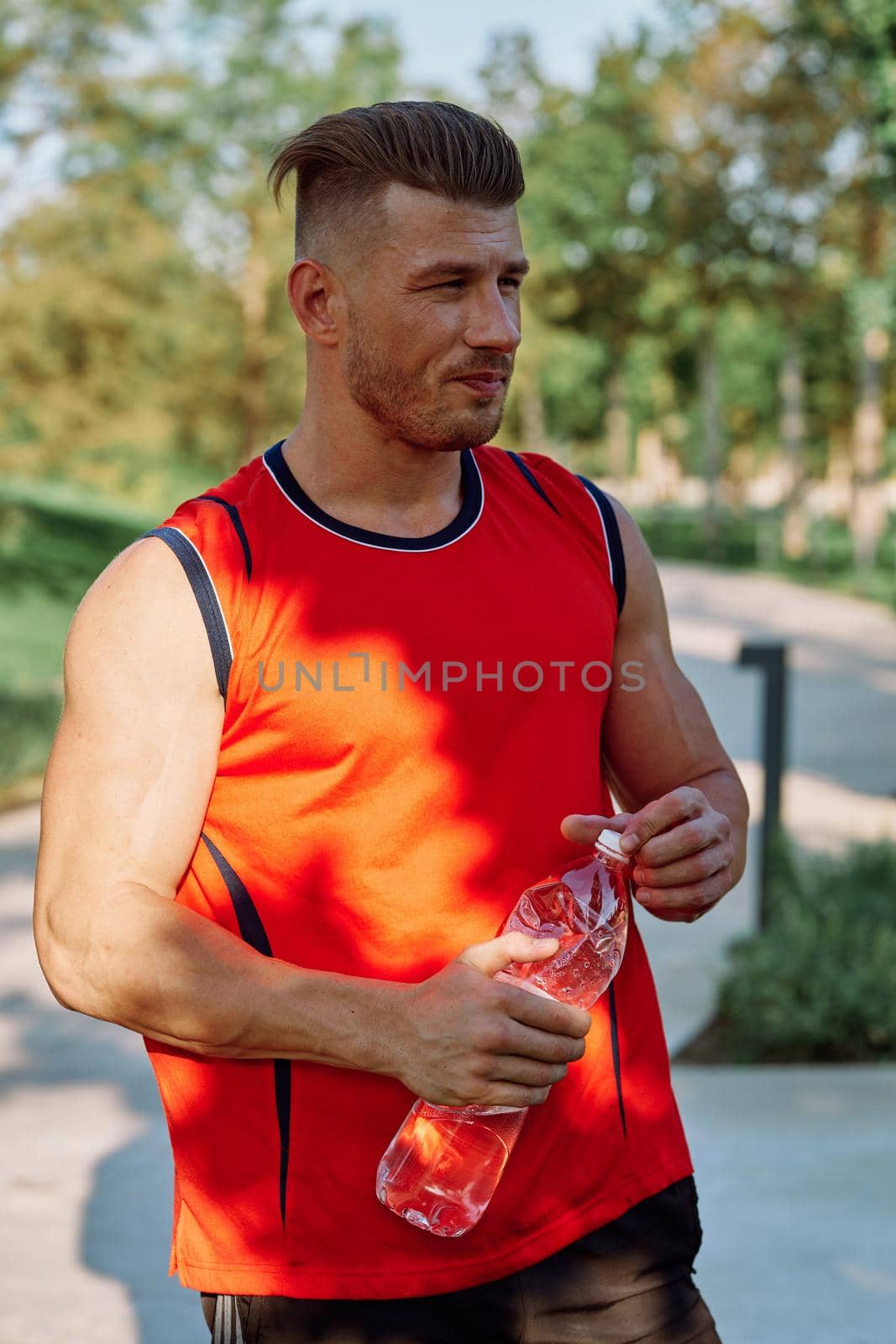 athletic man with dumbbells in his hands outdoors in the park. High quality photo