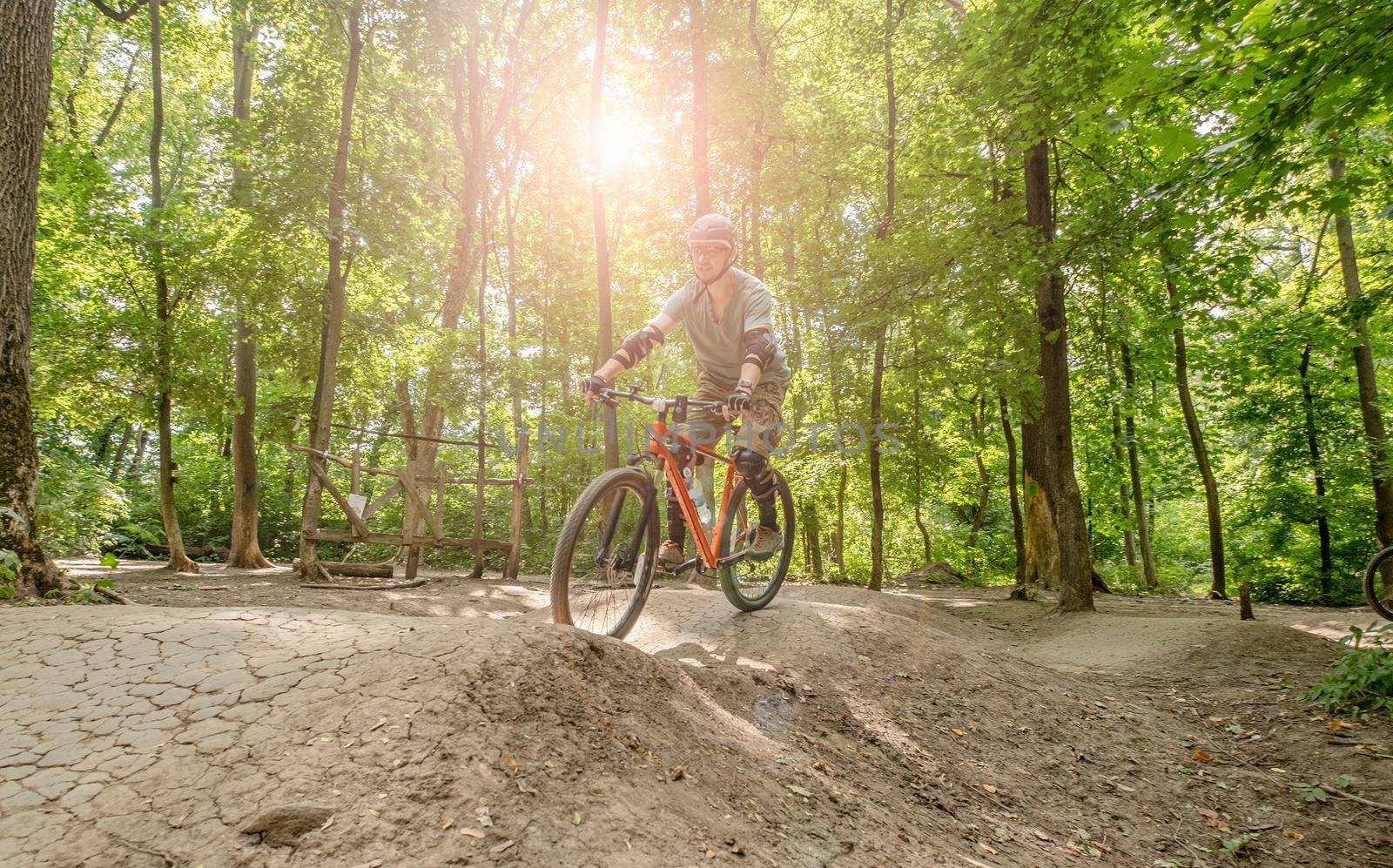 Man riding bicycle on forest road by tan4ikk1