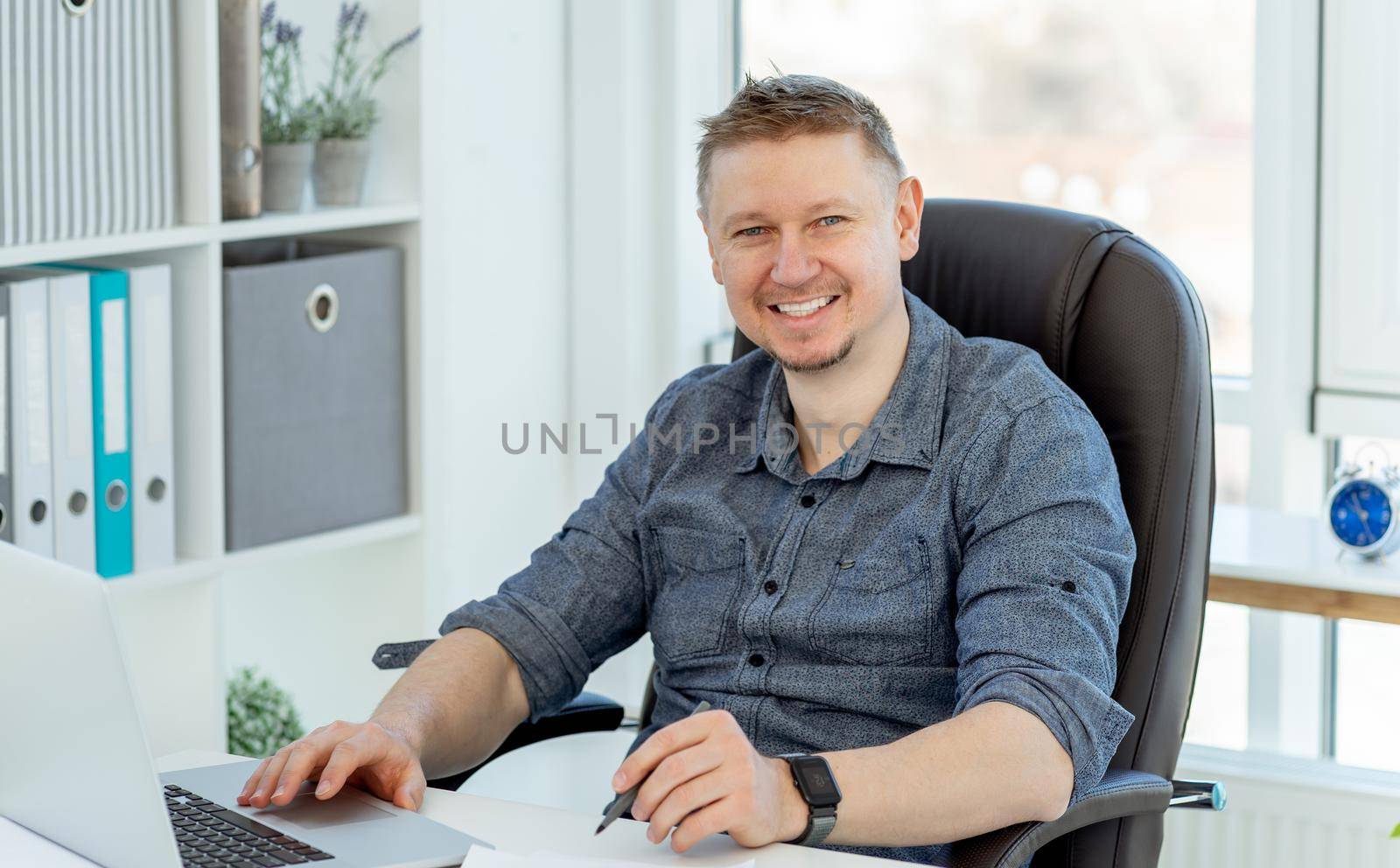Smiling man working in light office