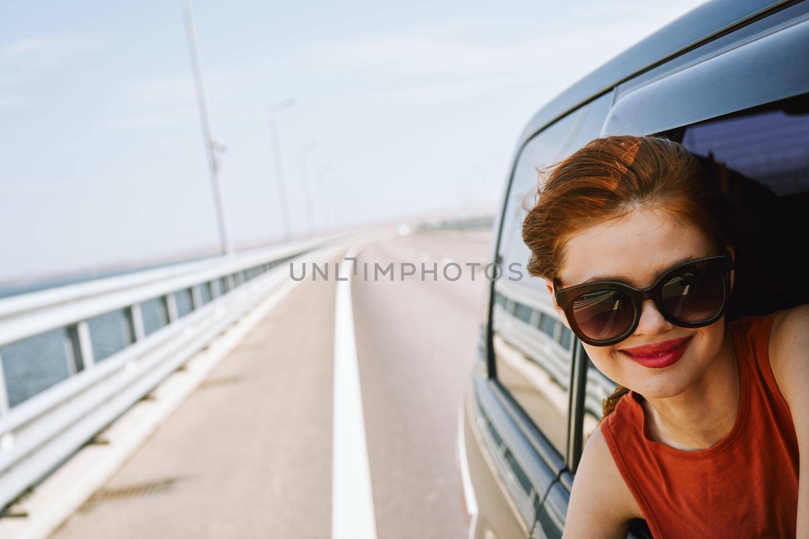 woman looking out of car window wearing sunglasses travel lifestyle. High quality photo