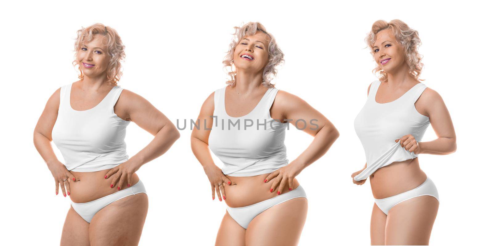 Smiling slimming middle aged model in white lingerie. Process of slimming. Isolated on white background.