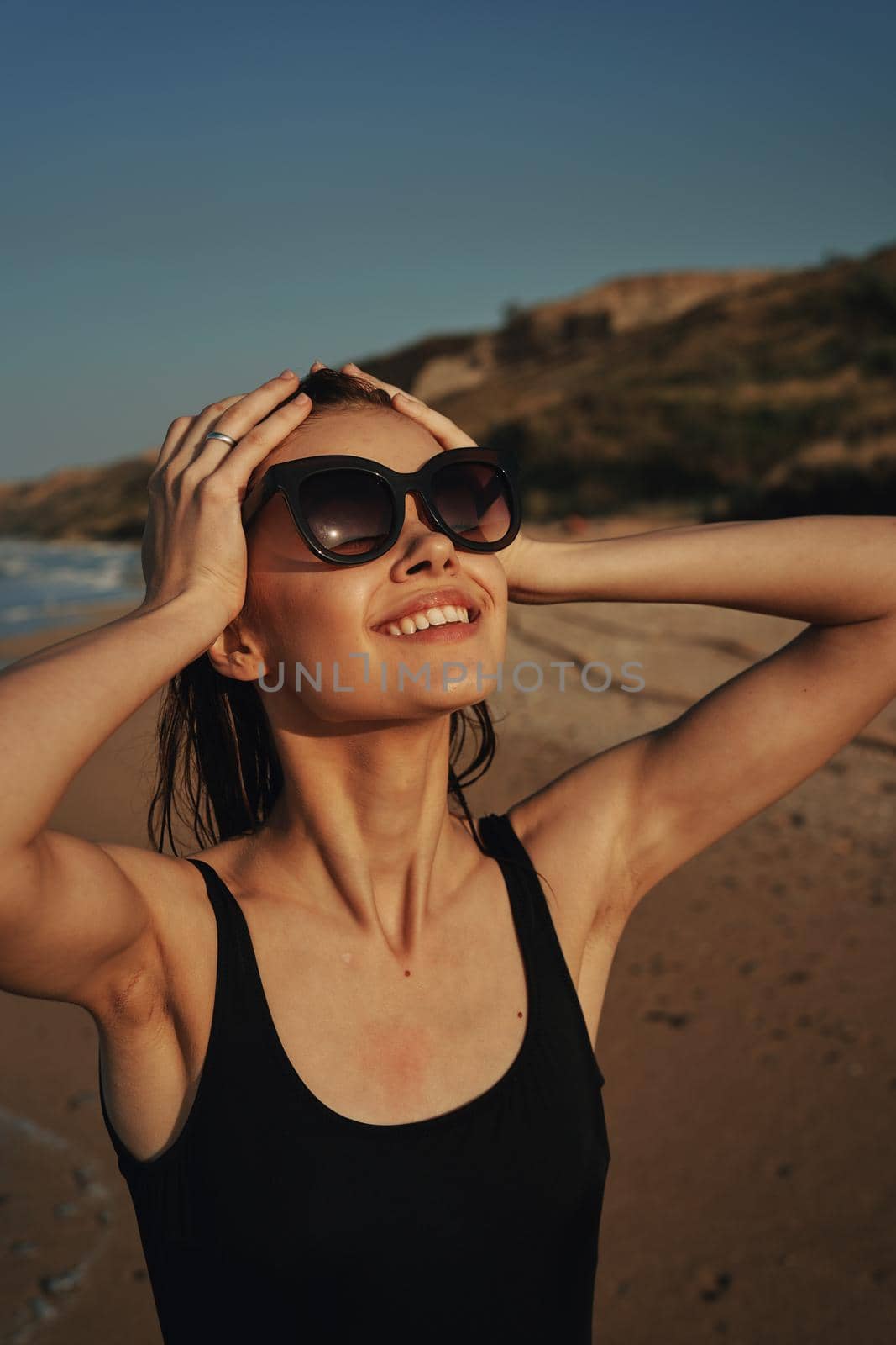 cheerful woman sunglasses posing black swimsuit island. High quality photo