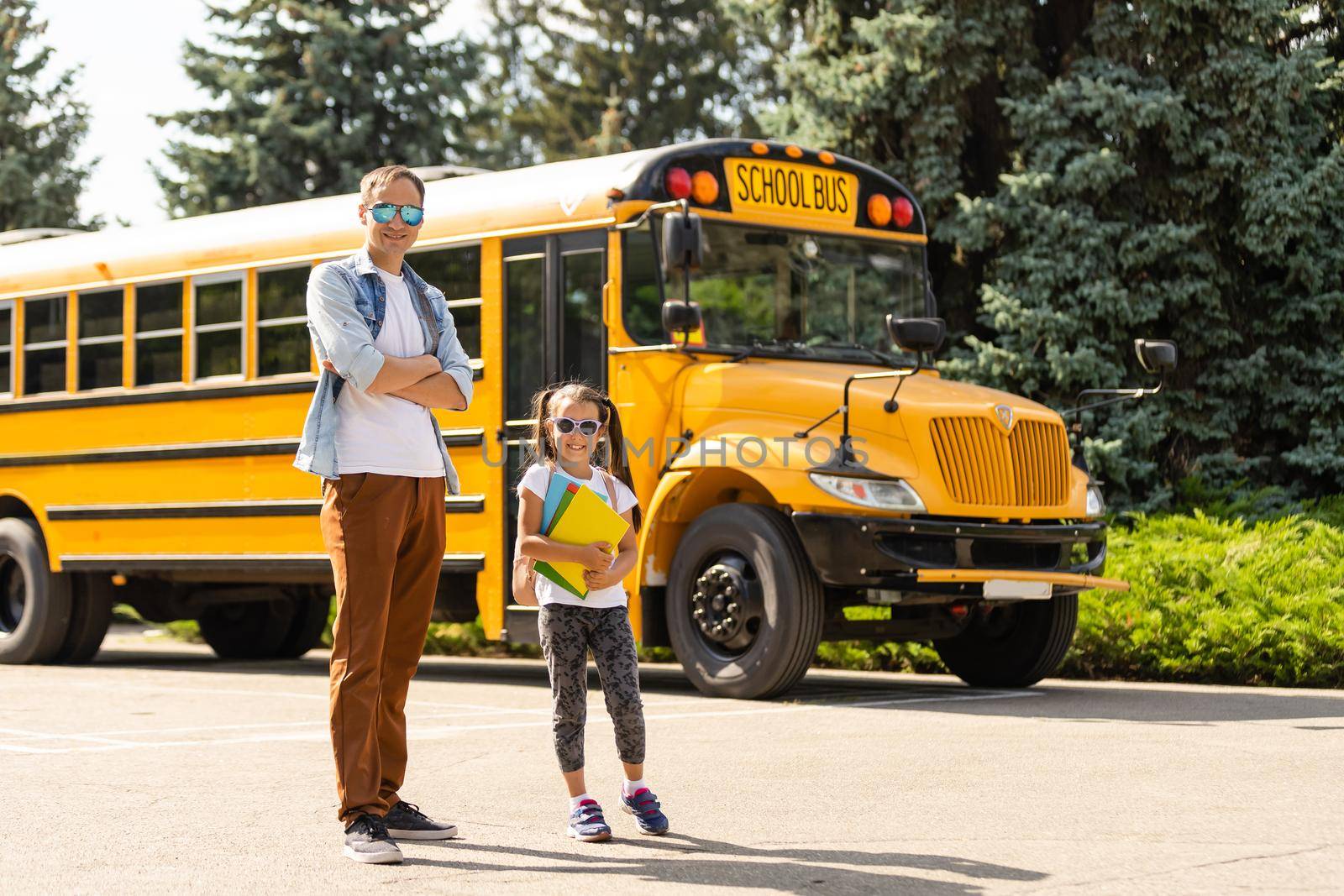 Girl with father going back to school near the school bus