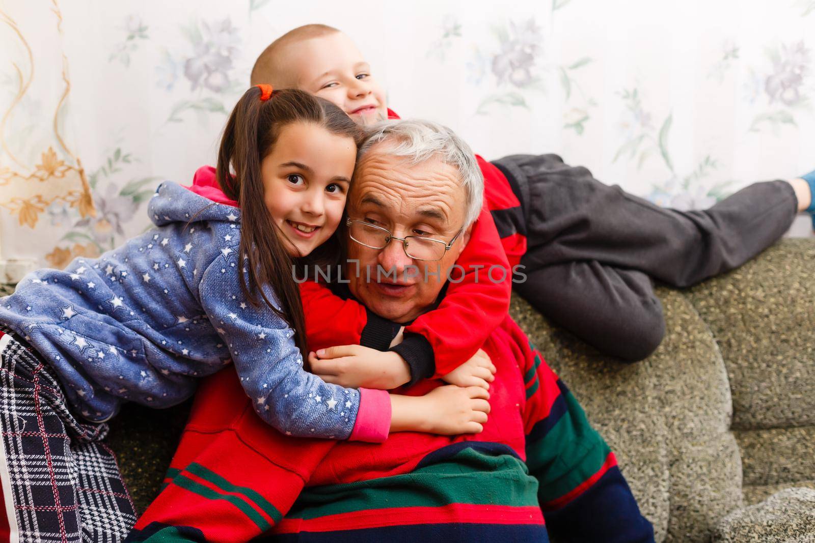 grandfather spends time with grandchildren in the living room by Andelov13