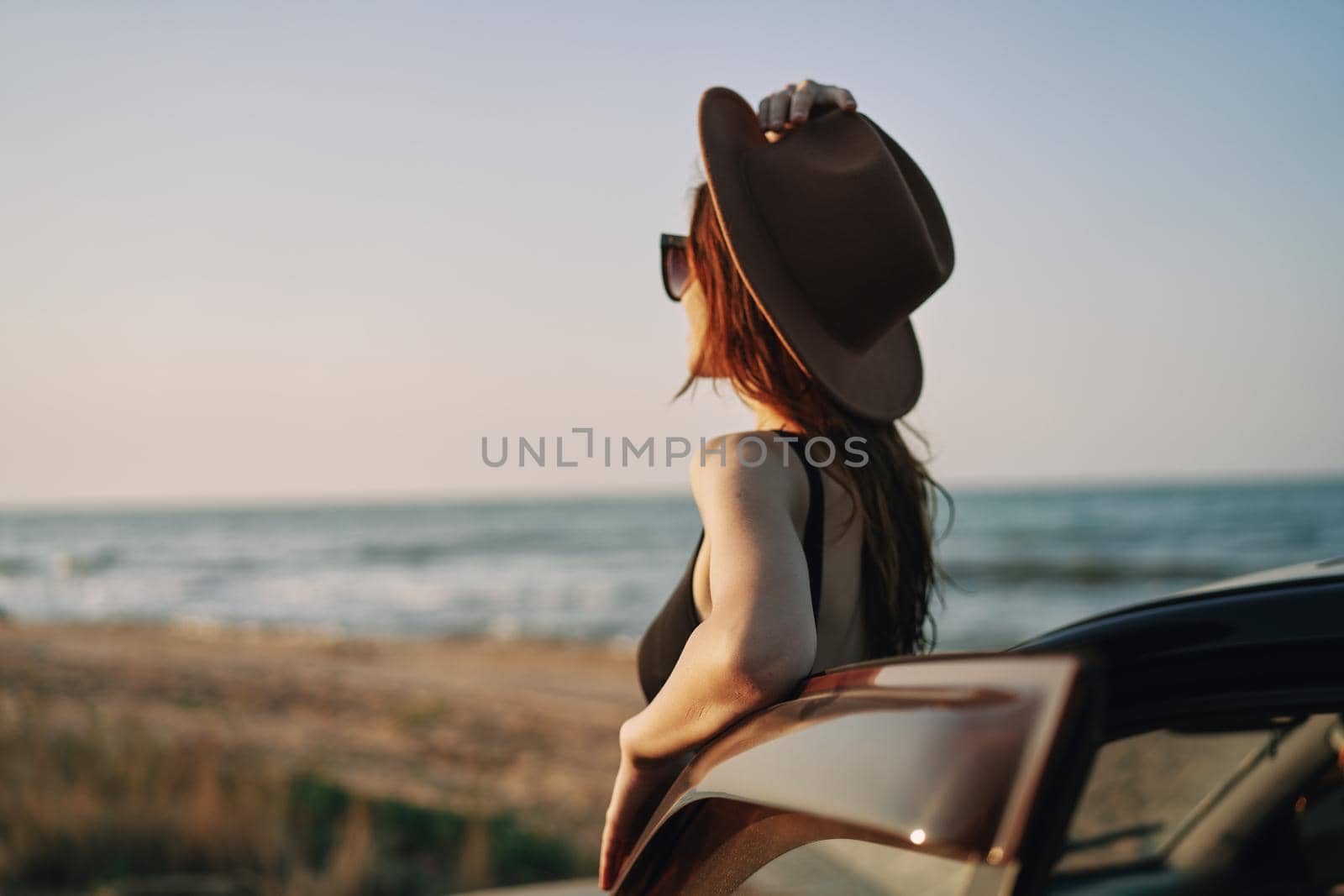 pretty woman in sunglasses near the car on the beach travel lifestyle. High quality photo