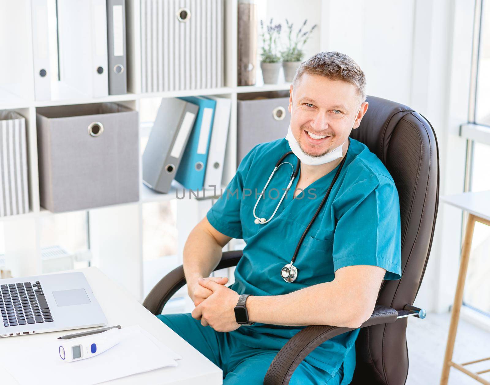 Smiling doctor wearing uniform in light office
