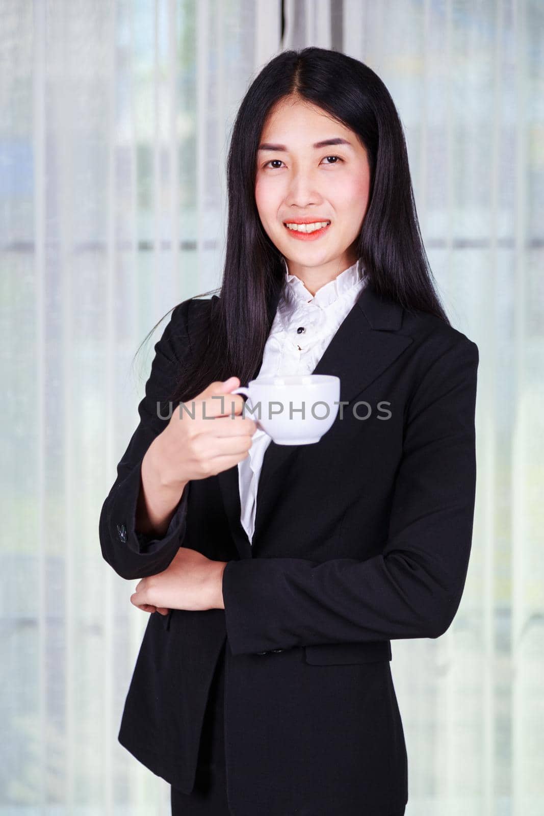 young business woman in suit with coffee or tea cup