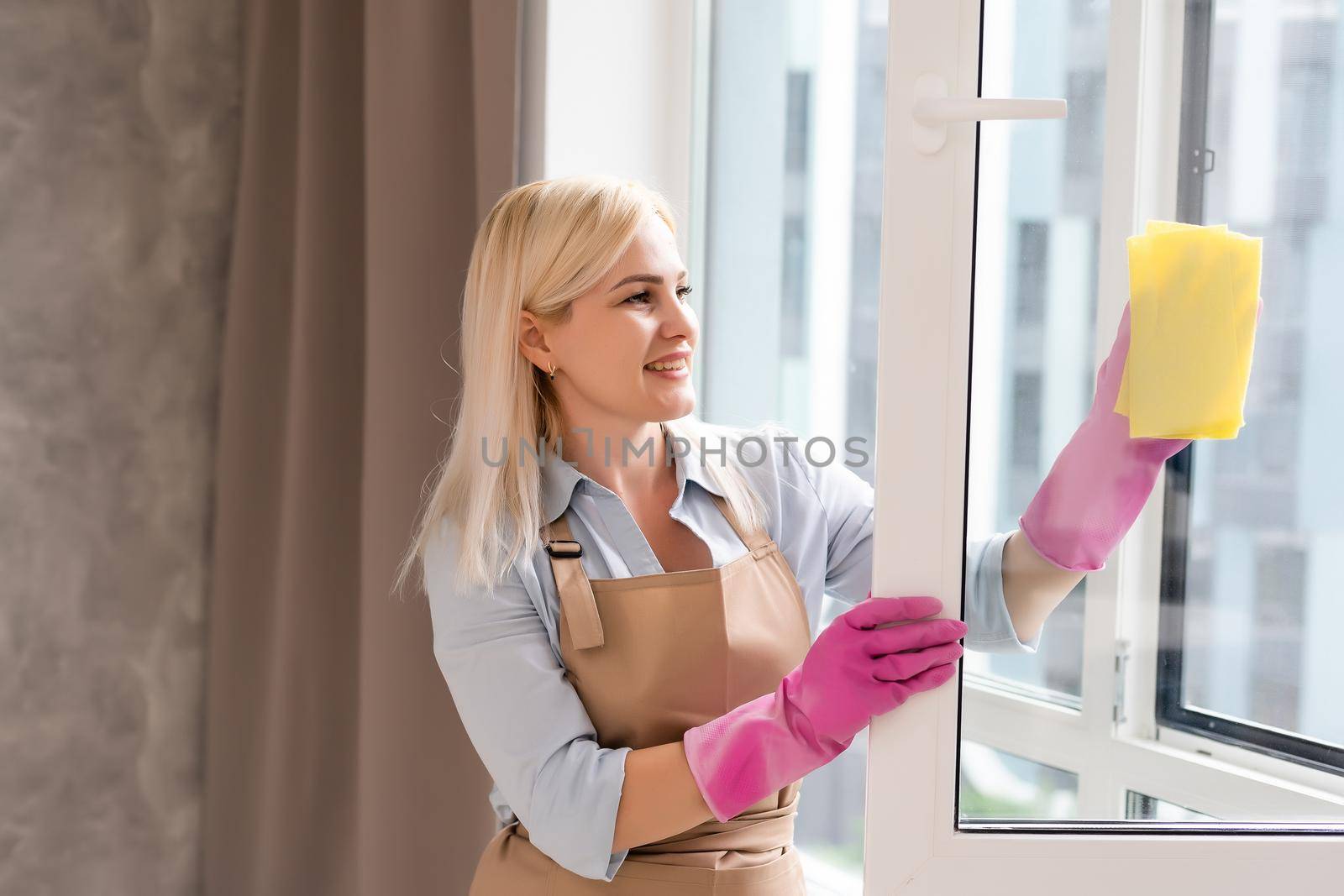 Young woman cleaning the window