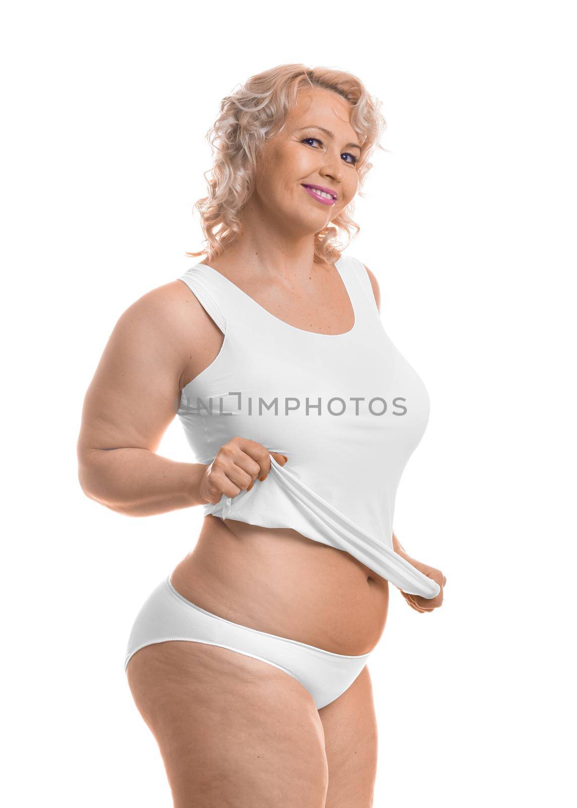 Portrait of a happy middle aged plus size model in white lingerie over white background.