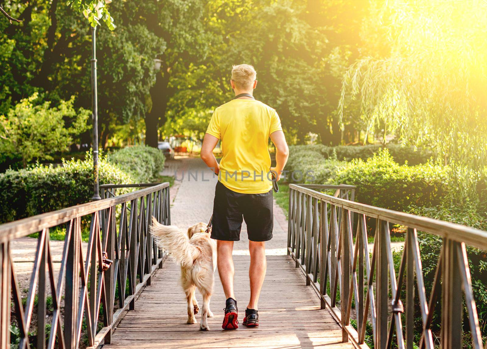 Man jogging across bridge with dog by tan4ikk1